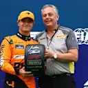 BUDAPEST, HUNGARY - JULY 20: Pole position qualifier Lando Norris of Great Britain and McLaren is presented with the Pirelli Pole Position trophy by Director of Pirelli F1 Mario Isola in parc ferme during qualifying ahead of the F1 Grand Prix of Hungary at Hungaroring on July 20, 2024 in Budapest, Hungary. (Photo by Bryn Lennon - Formula 1/Formula 1 via Getty Images)