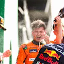 ZANDVOORT, NETHERLANDS - AUGUST 25: Lando Norris of McLaren and Great Britain celebrates finishing in first position with Max Verstappen of Oracle Red Bull Racing and The Netherlands  and Charles Leclerc of Ferrari and Monaco during the F1 Grand Prix of Netherlands at Circuit Zandvoort on August 25, 2024 in Zandvoort, Netherlands. (Photo by Peter Fox - Formula 1/Formula 1 via Getty Images)