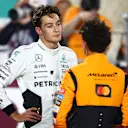 LUSAIL CITY, QATAR - NOVEMBER 30: Second placed Lando Norris of Great Britain and McLaren and Third placed George Russell of Great Britain and Mercedes talk in parc ferme during the Sprint ahead of the F1 Grand Prix of Qatar at Lusail International Circuit on November 30, 2024 in Lusail City, Qatar. (Photo by Mark Thompson/Getty Images)