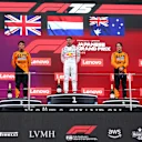 SUZUKA, JAPAN - APRIL 06: Second placed Lando Norris of Great Britain and McLaren Race winner Max Verstappen of the Netherlands and Oracle Red Bull Racing Third placed Oscar Piastri of Australia and McLaren and Hugh Bird, Race Engineer of Oracle Red Bull Racing on the podium during the F1 Grand Prix of Japan at Suzuka Circuit on April 06, 2025 in Suzuka, Japan. (Photo by Clive Rose/Getty Images)