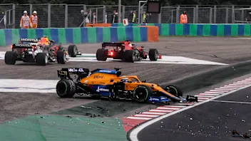 McLaren's Australian driver Daniel Ricciardo stands on the side of the track after his car was