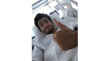 Toro Rosso's Carlos Sainz gives a thumbs-up from hospital after his FP3 crash in Sochi