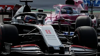 Haas driver Romain Grosjean of France steers his car followed by Racing Point driver Nico
