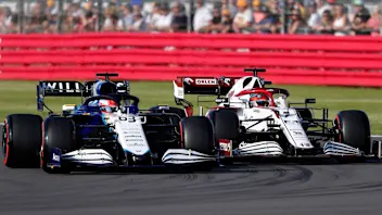 Williams' British driver George Russell (L) and Alfa Romeo's Finnish driver Kimi Raikkonen drive at