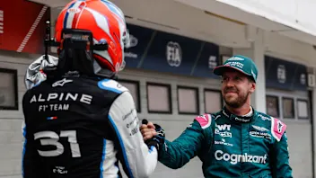 Alpine's French driver Esteban Ocon shakes hands with Aston Martin's German driver Sebastian Vettel