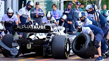Pit crew change a tyre on the car of Alpha Tauri Japanese driver Yuki Tsunoda during the second