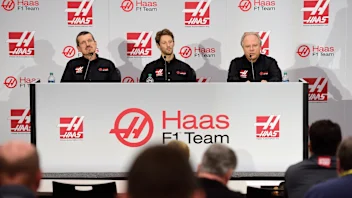 (R-L) Gene Haas, owner of Haas F1 Team, speaks with the media as Romain Grosjean of France and