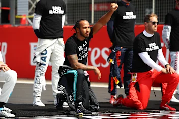 NORTHAMPTON, ENGLAND - AUGUST 09: Lewis Hamilton of Great Britain and Mercedes GP takes a knee on