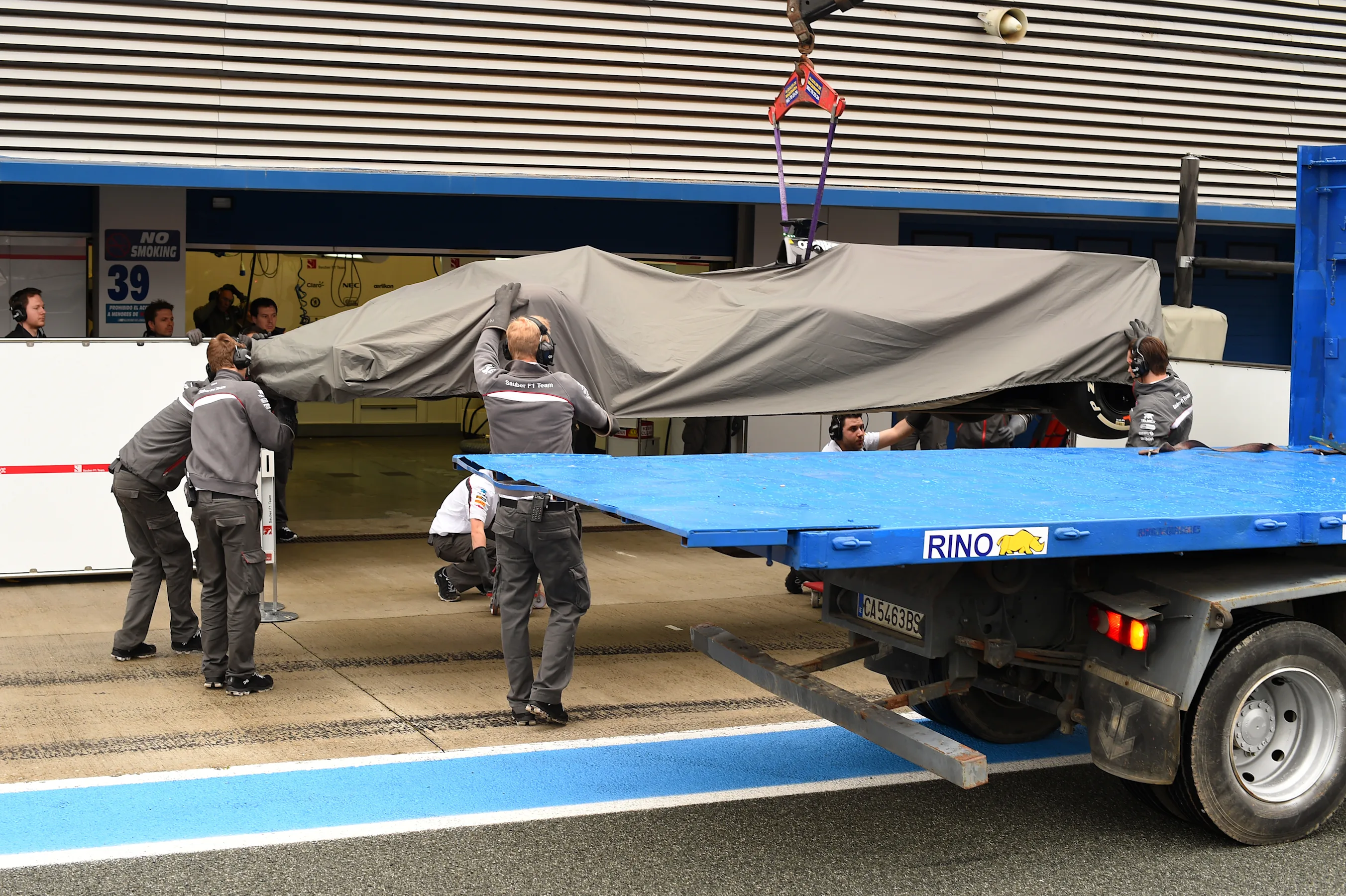 The Sauber C33 of Adrian Sutil (GER) is returned to the pit lane on a transporter after he span