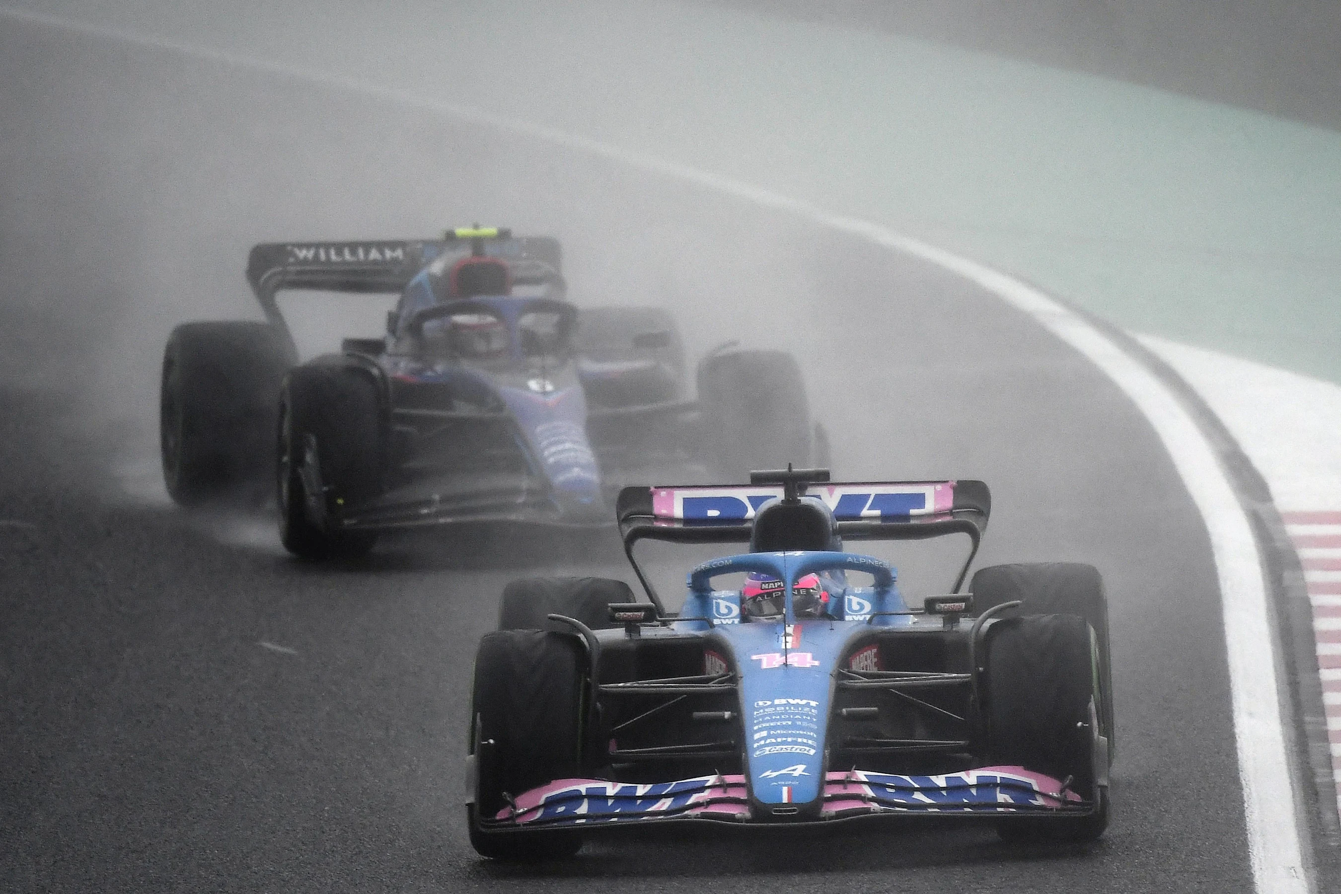 Alpine's Spanish driver Fernando Alonso (C) drives in front of Williams' Canadian driver Nicholas
