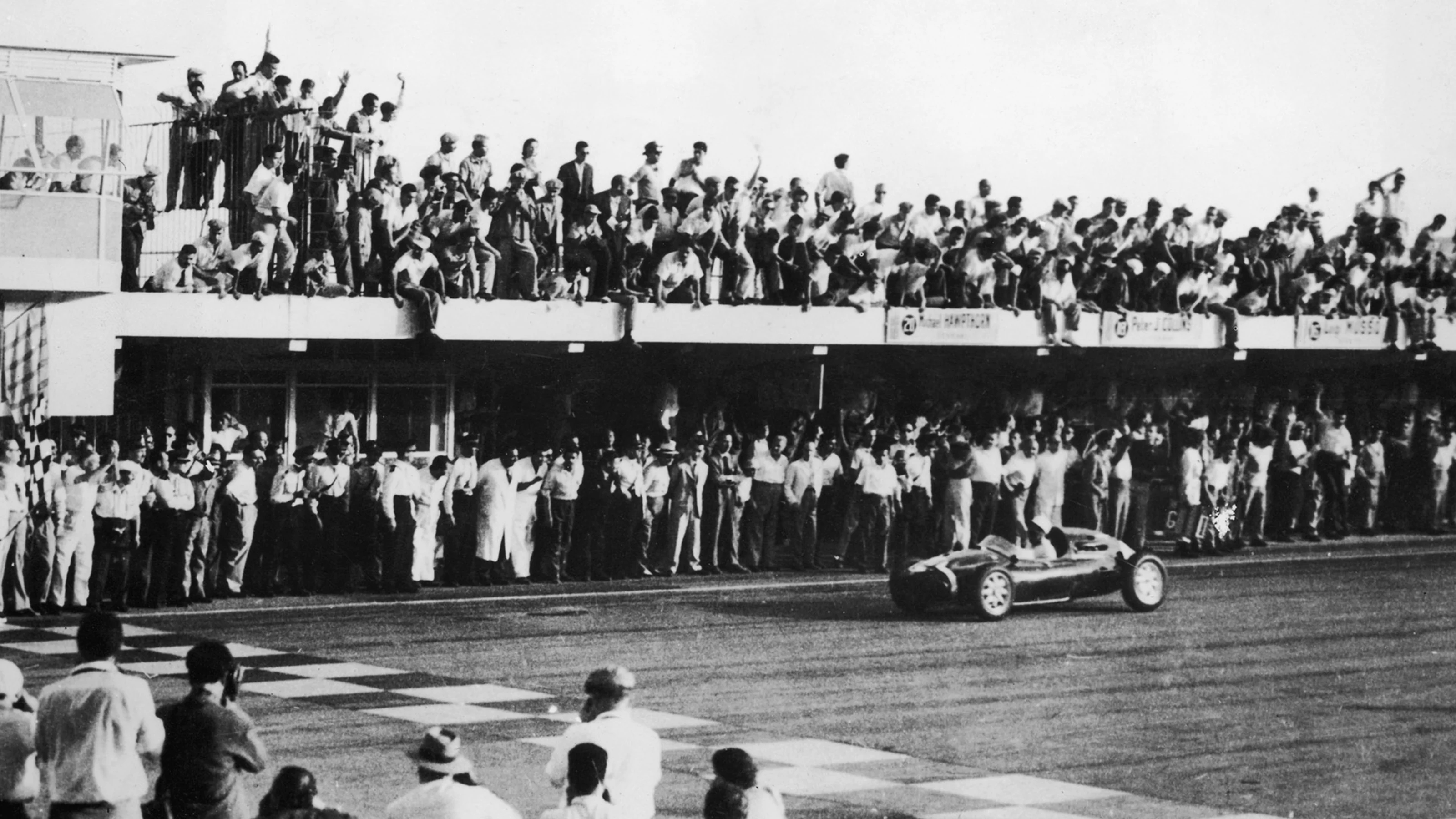 English racing driver Stirling Moss crosses the finishing line in a Cooper-Climax T43 to win the