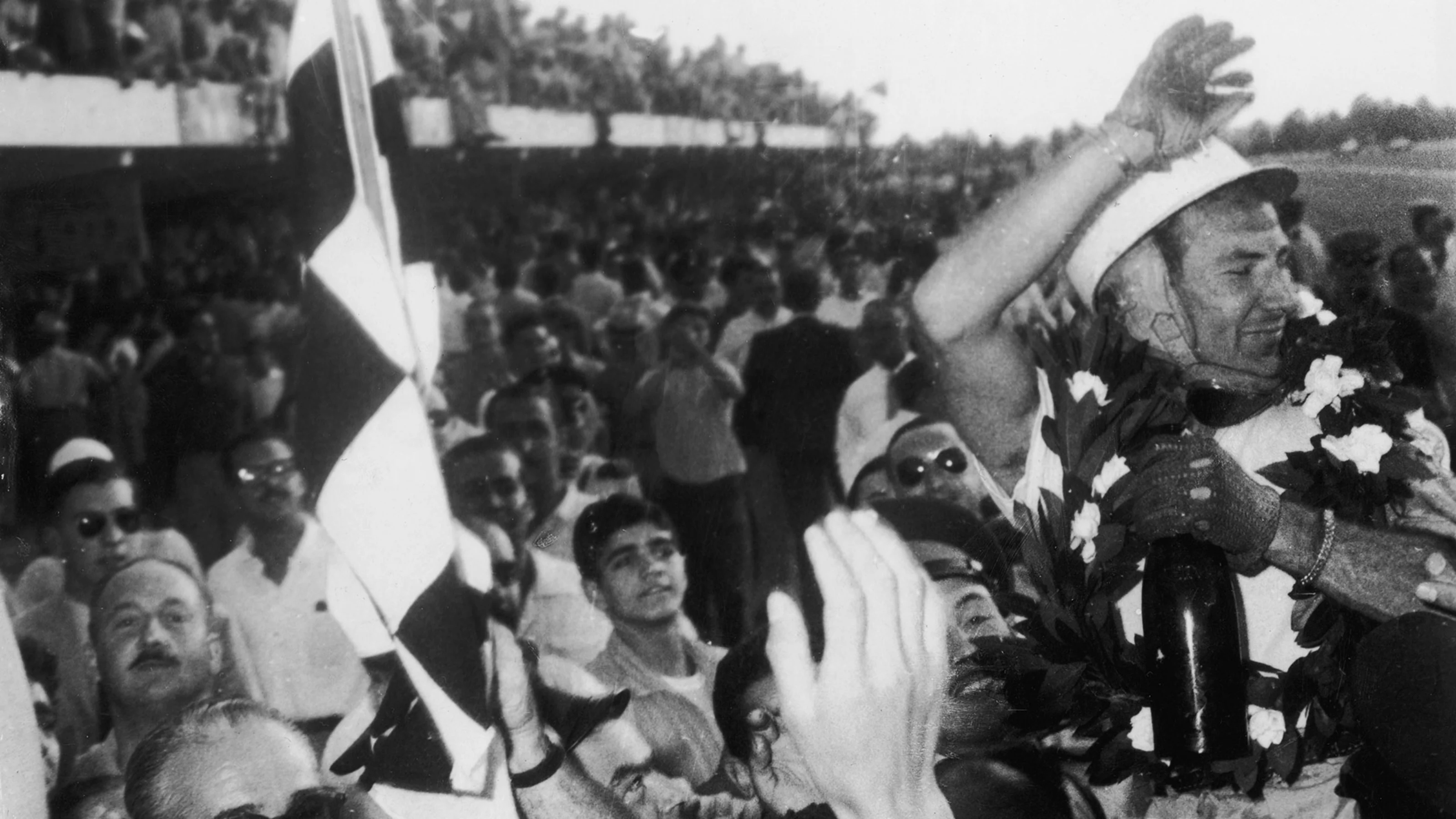 English racing driver Stirling Moss is cheered by the crowd after winning the Argentine Grand Prix