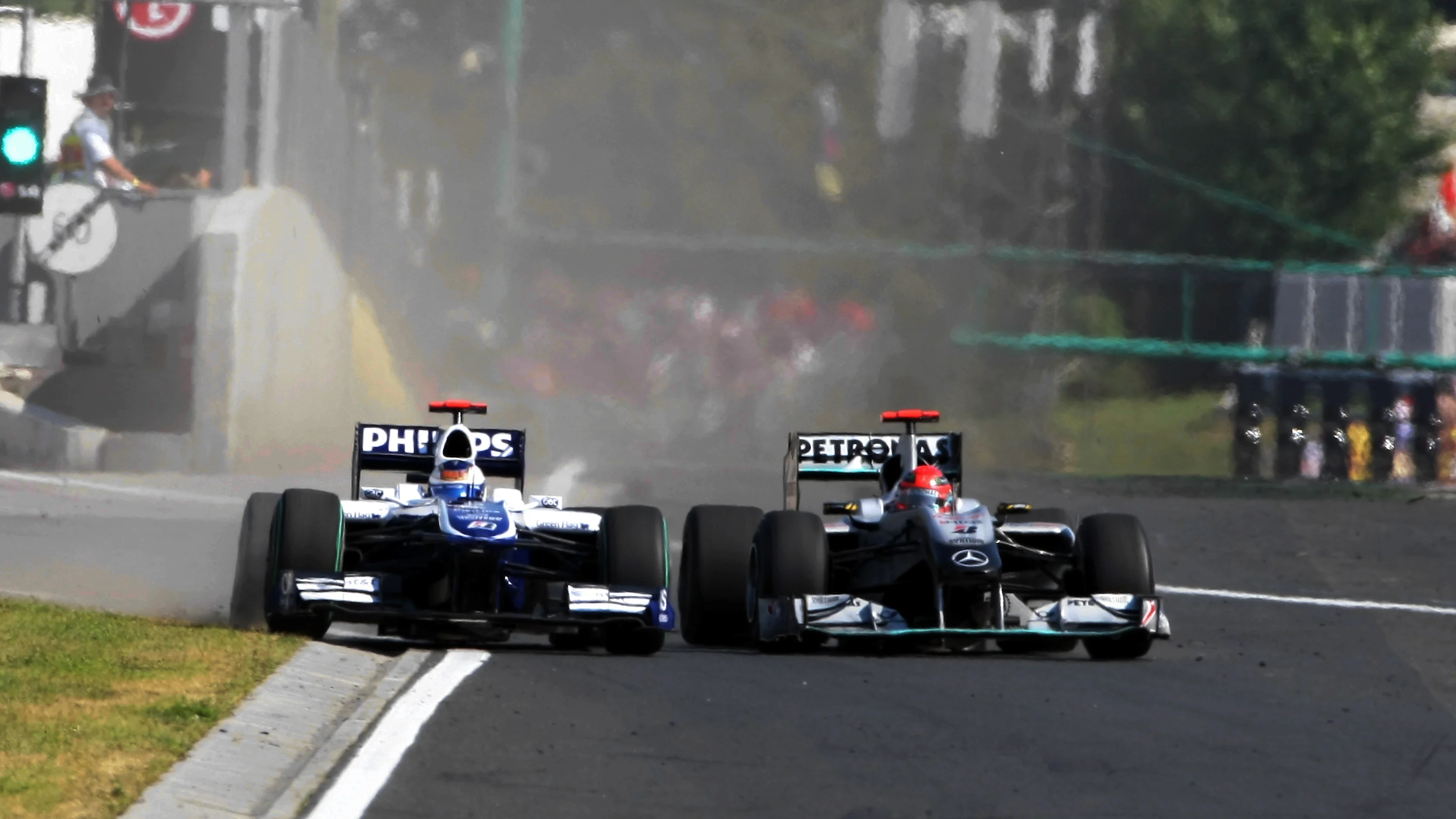 Michael Schumacher (GER) Mercedes GP MGP W01 squeezes Rubens Barrichello (BRA) Williams FW32 into
