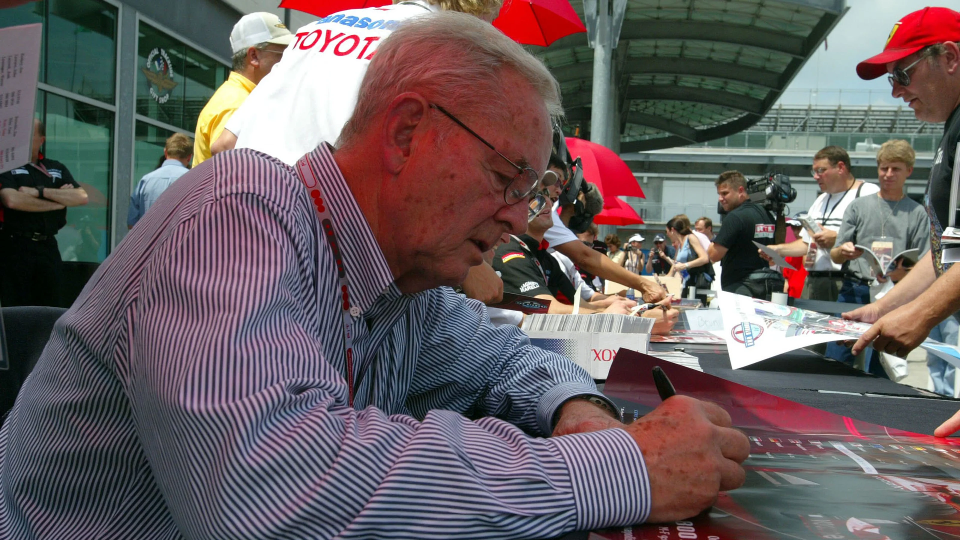 Former Grand Prix driver Phil Hill (USA) signs autographs for fans. Formula One World
