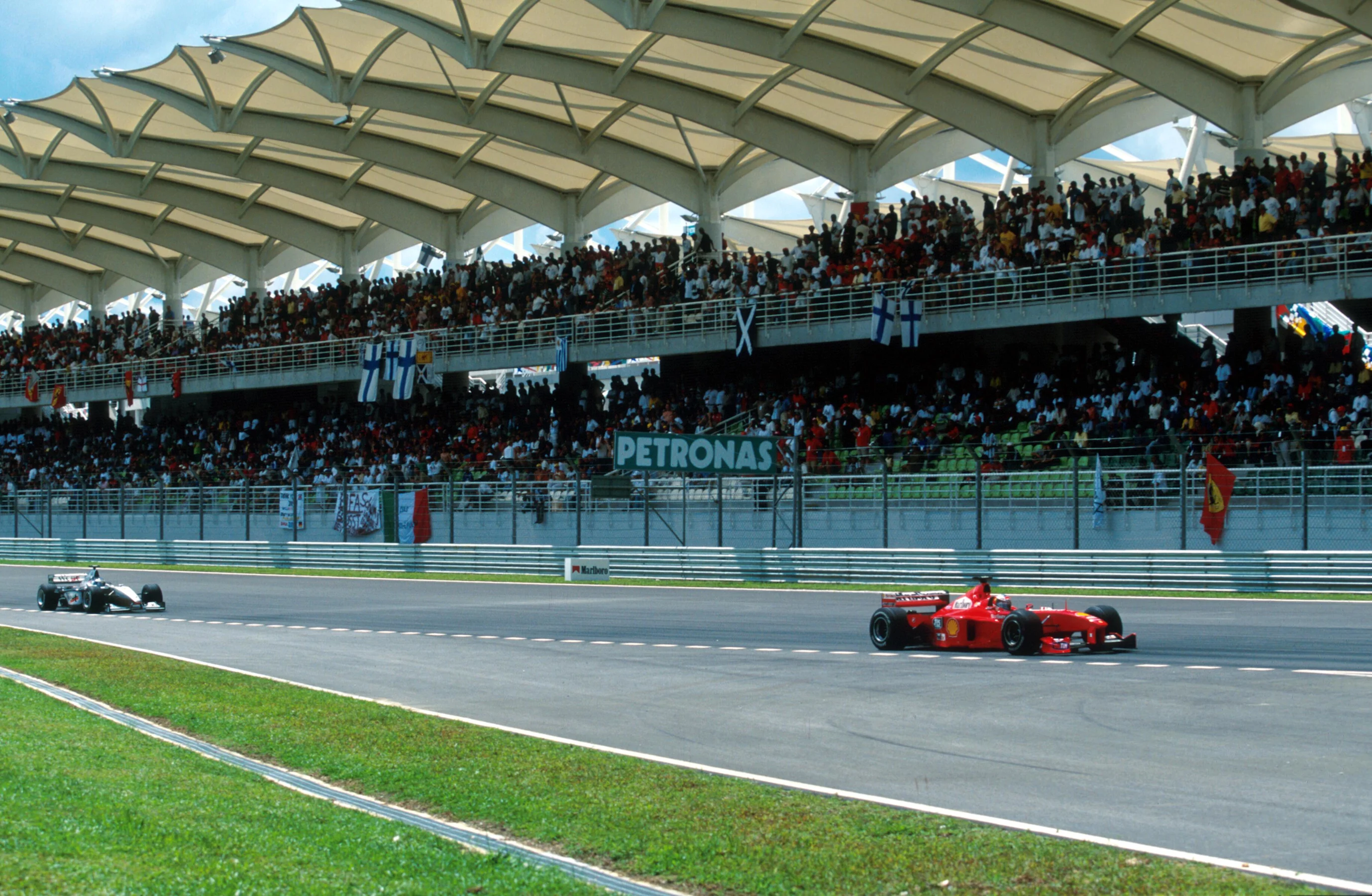 Michael Schumacher(GER) Ferrari F399 leads Hakkinen in front of the impressive