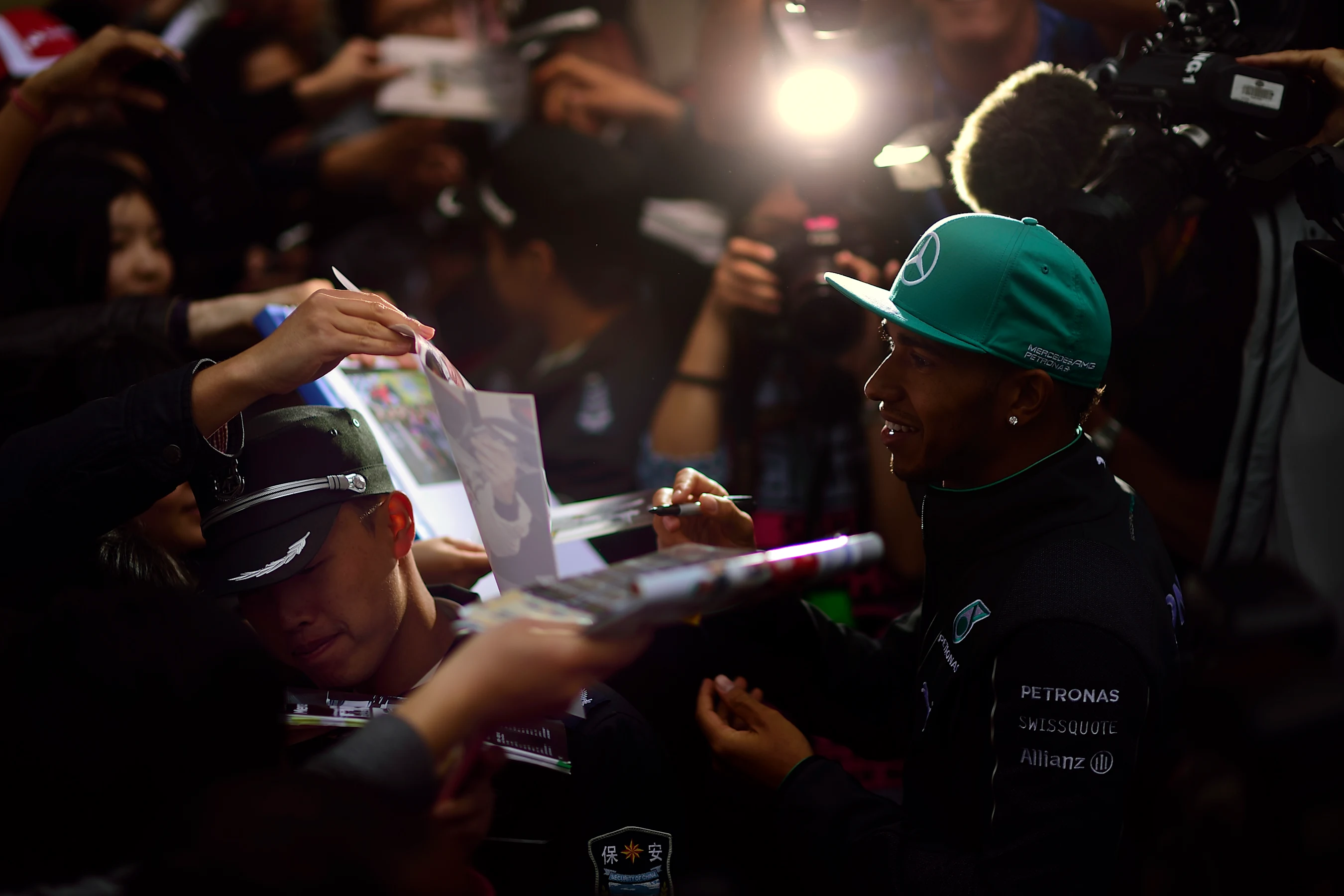 Mercedes' Lewis Hamilton signs autographs for fans