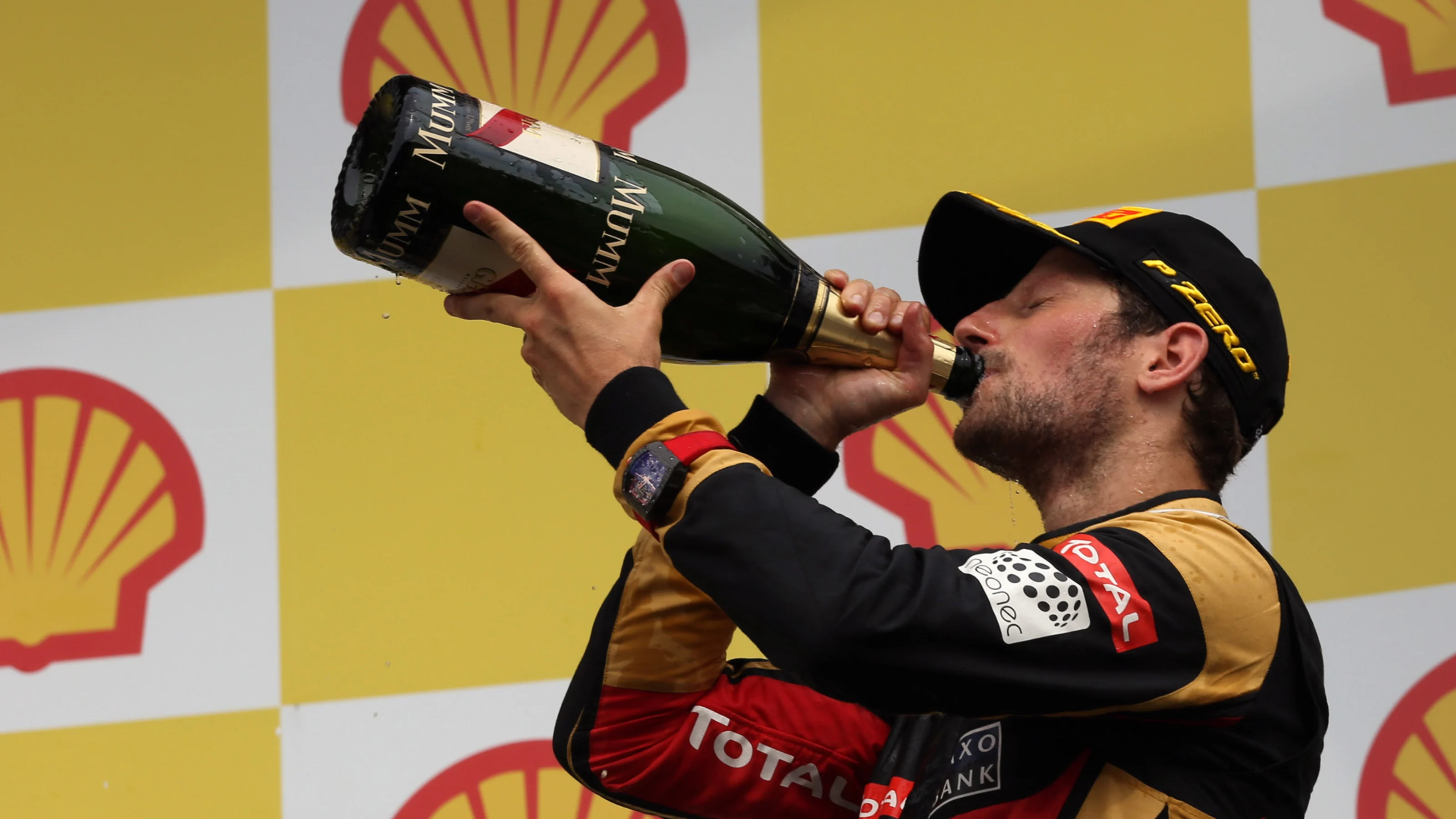 Romain Grosjean (FRA) Lotus F1 celebrates with the champagne on the podium at Formula One World