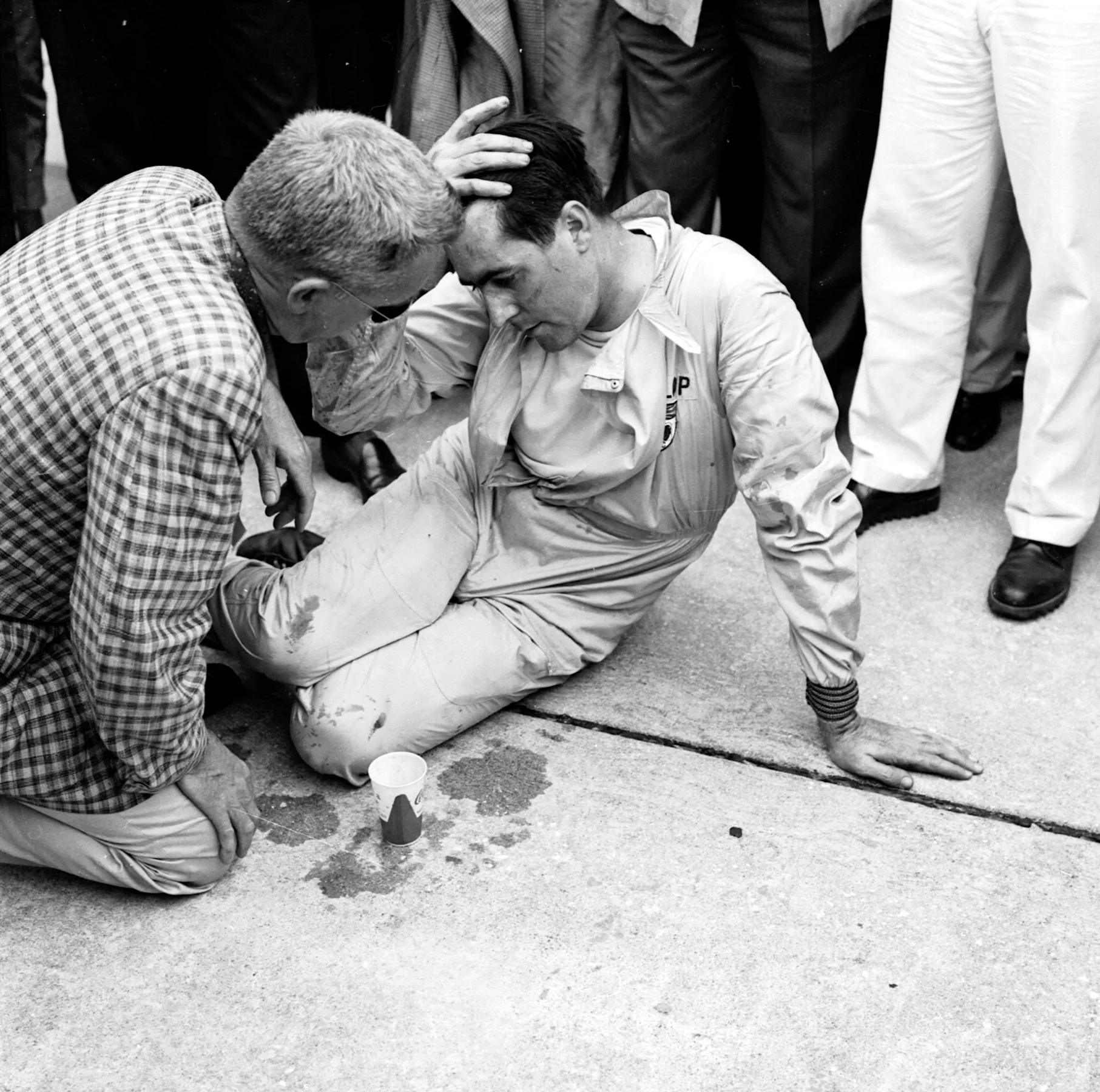 Jack Brabham collapsed after pushing his Cooper T51-Climax across the line to finish 4th and clinch