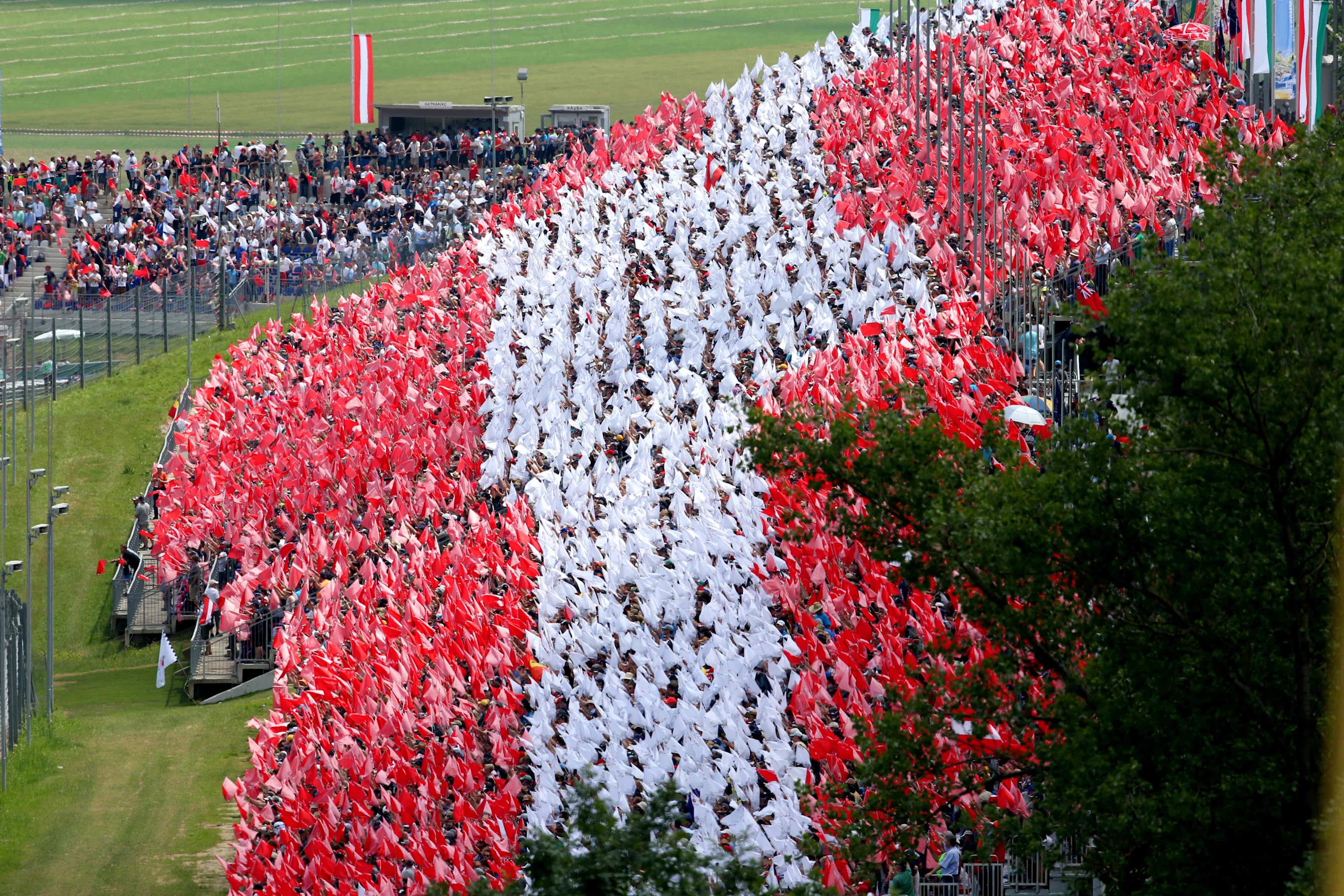 Fans with flags in the grandstand to make the Austrian National flag. Formula One World