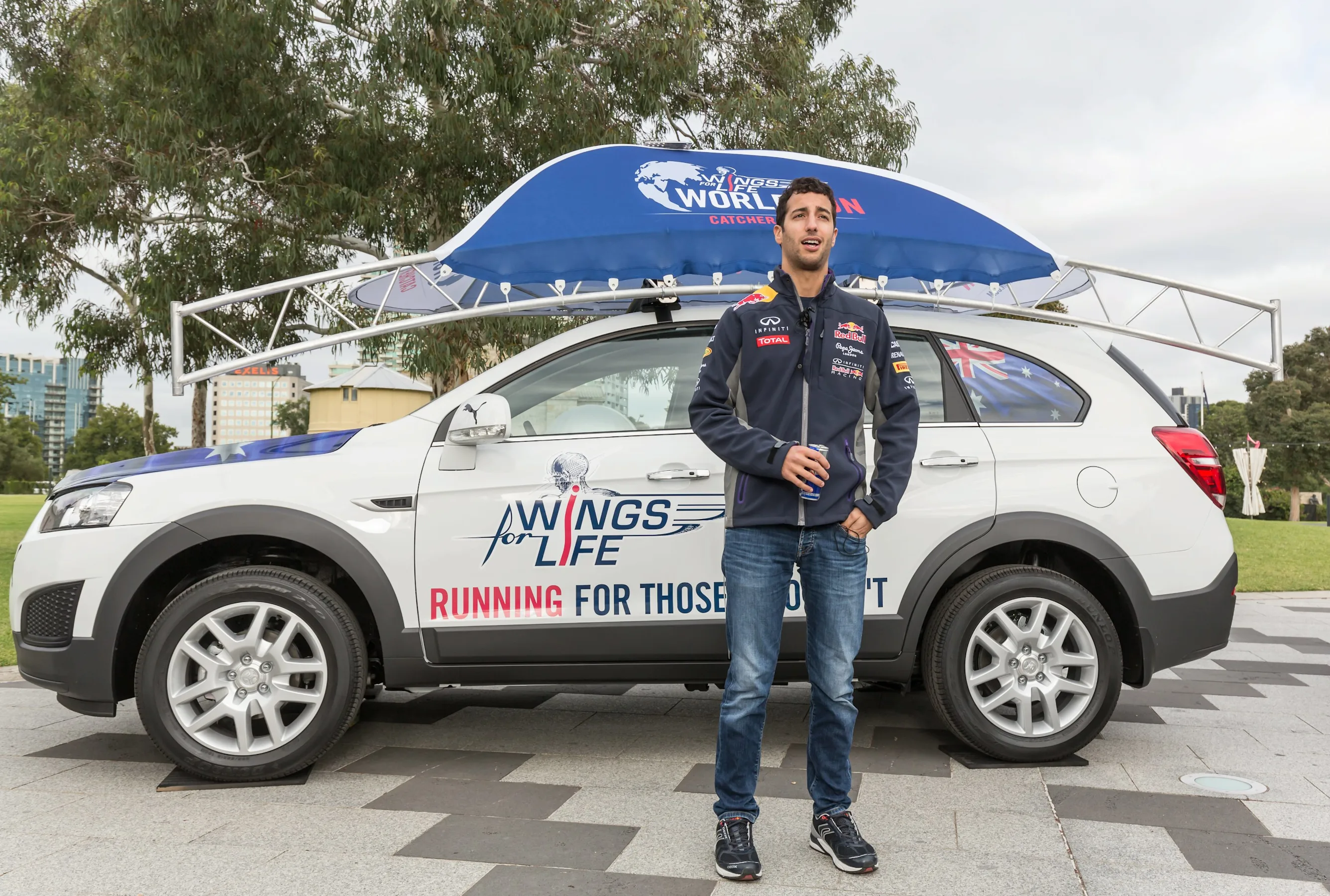 Daniel Ricciardo poses for a portrait infront of the chase car during the Daniel Ricciardo x Wings