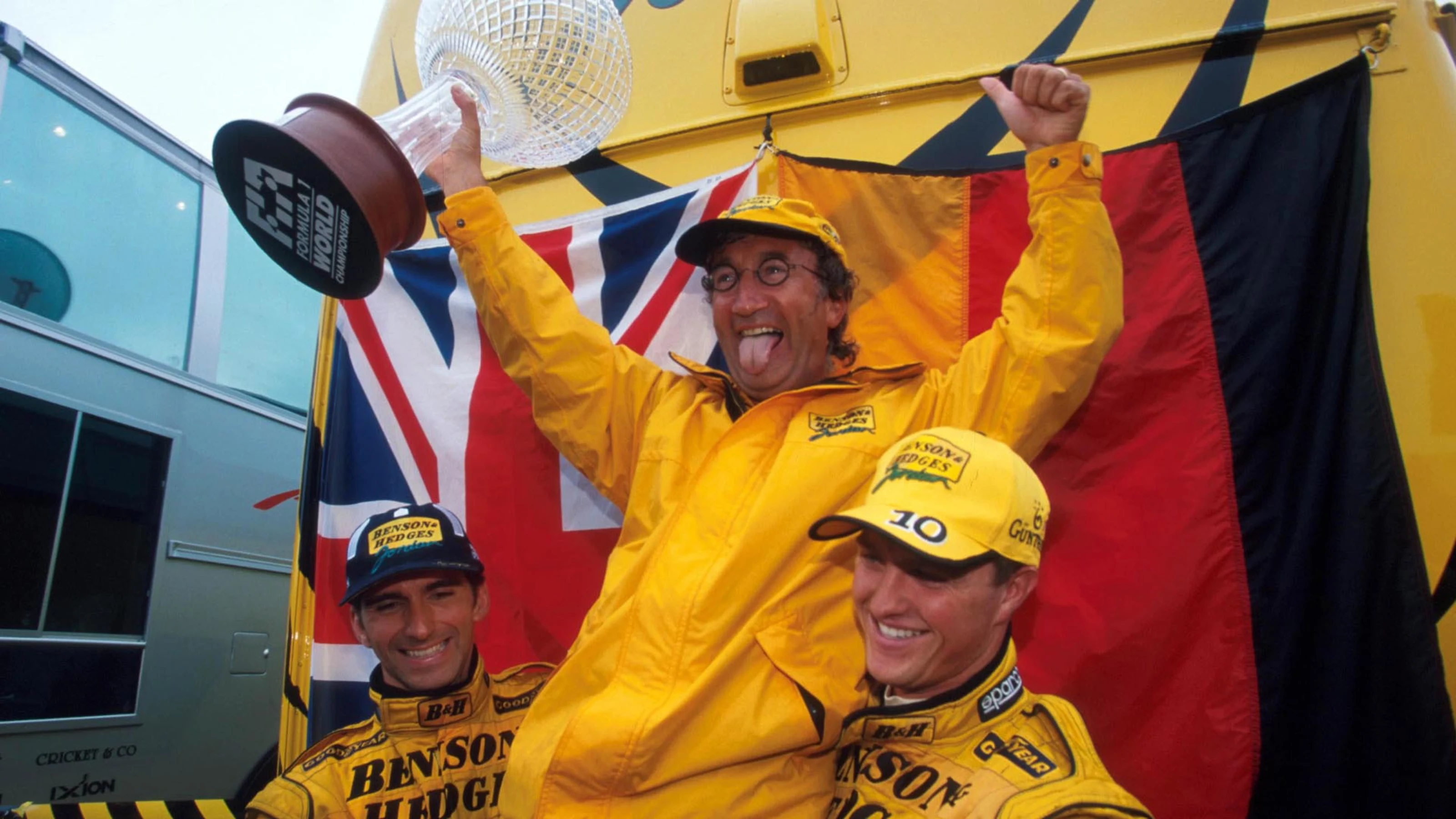 An overjoyed Eddie Jordan (centre) is hoisted aloft by his first Jordan race winner Damon Hill