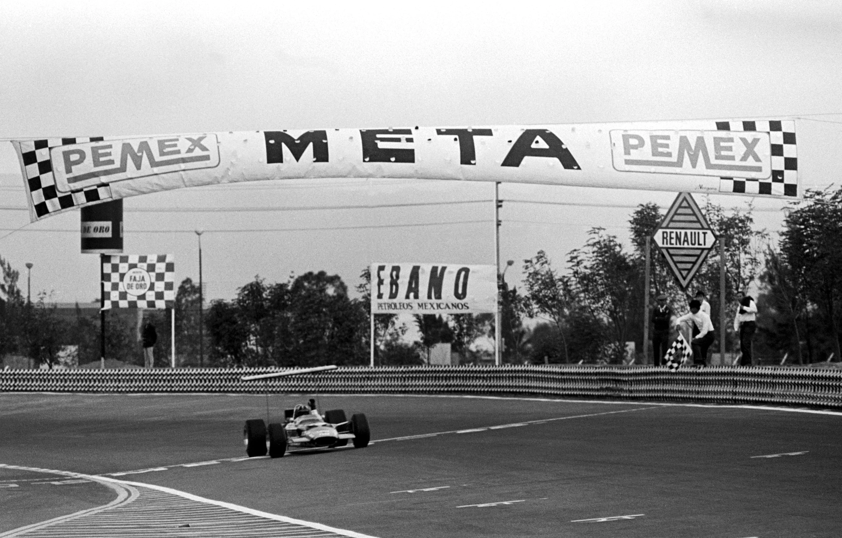 Graham Hill (GBR) Lotus 49B crosses the finish line to take race victory and clinch his second