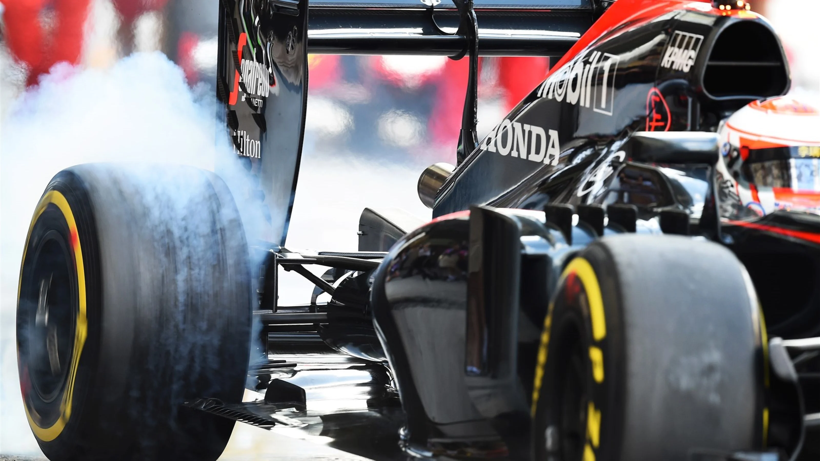Jenson Button (GBR) McLaren MP4-30 and tyre smoke at Formula One World Championship, Rd19, Abu