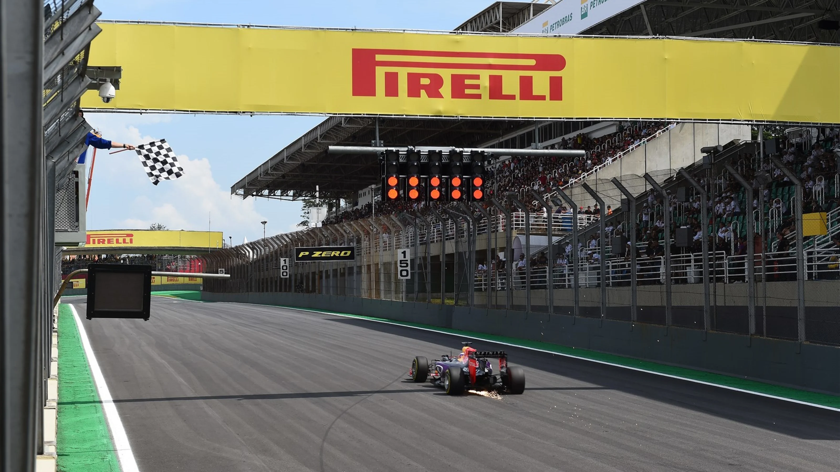 Daniel Ricciardo (AUS) Red Bull Racing RB11 and sparks and takes the chequered flag at the end of