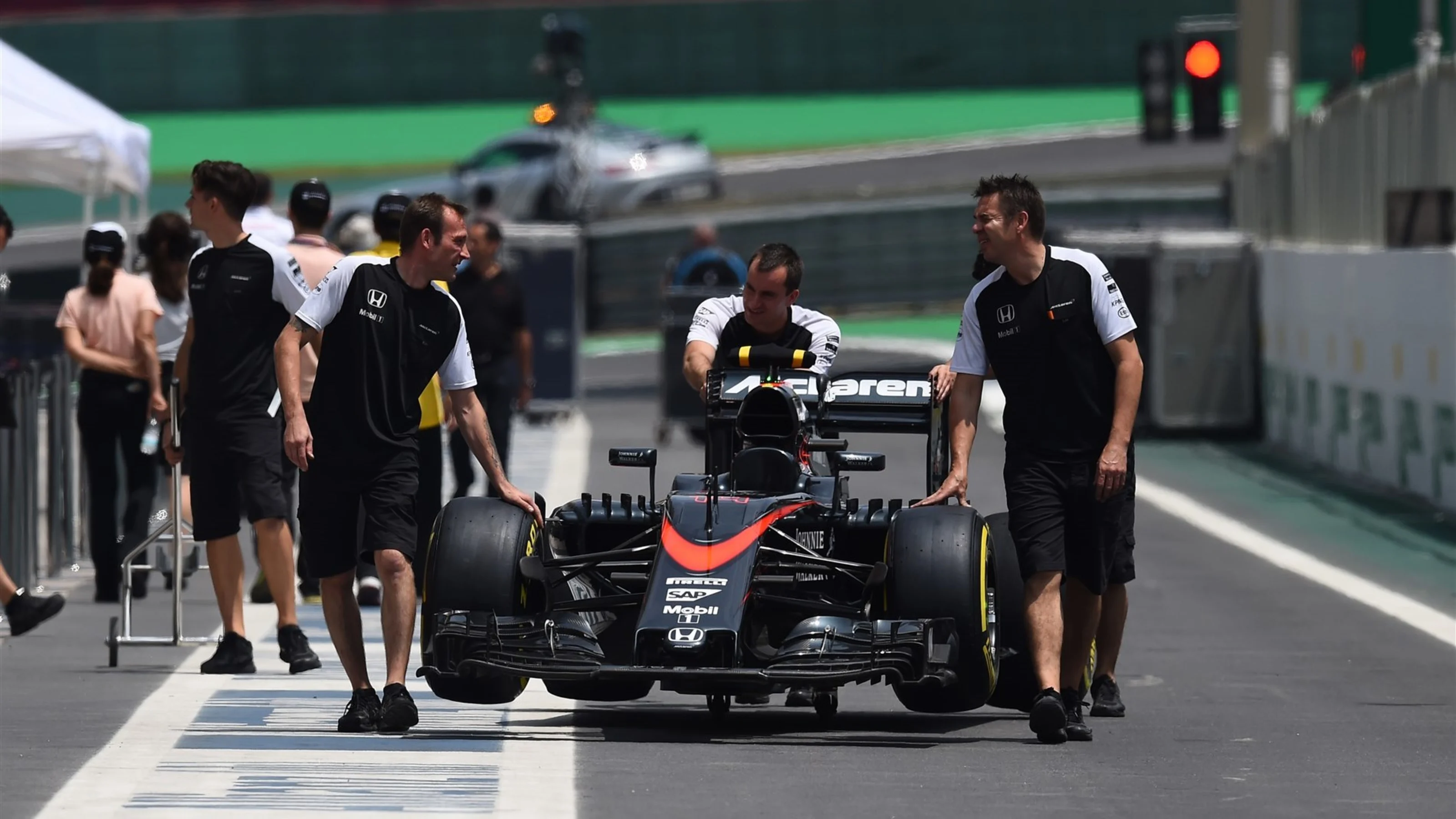 McLaren mechanics with McLaren MP4-30 in pit lane at Formula One World Championship, Rd18,