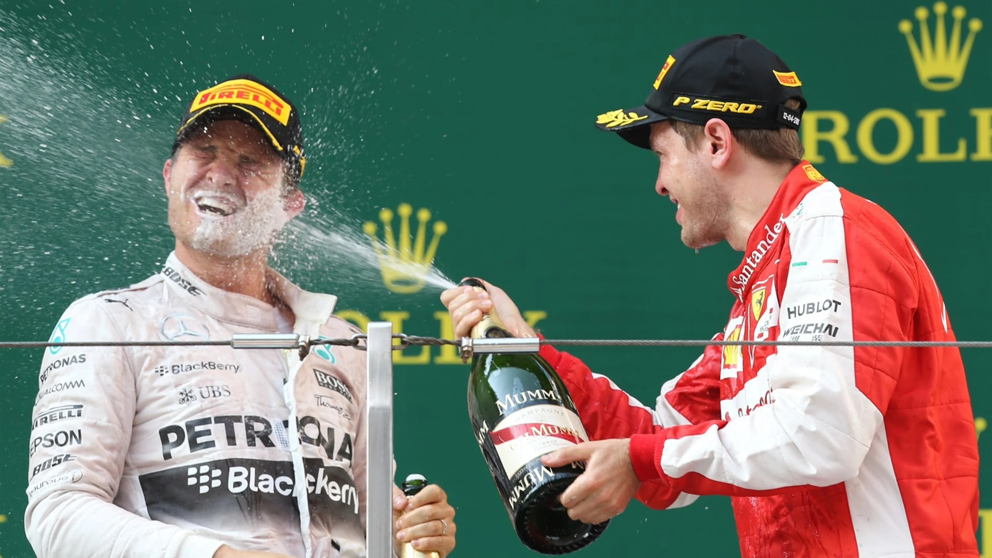 Sebastian Vettel (GER) Ferrari celebrates with Nico Rosberg (GER) Mercedes AMG F1 and champagne on