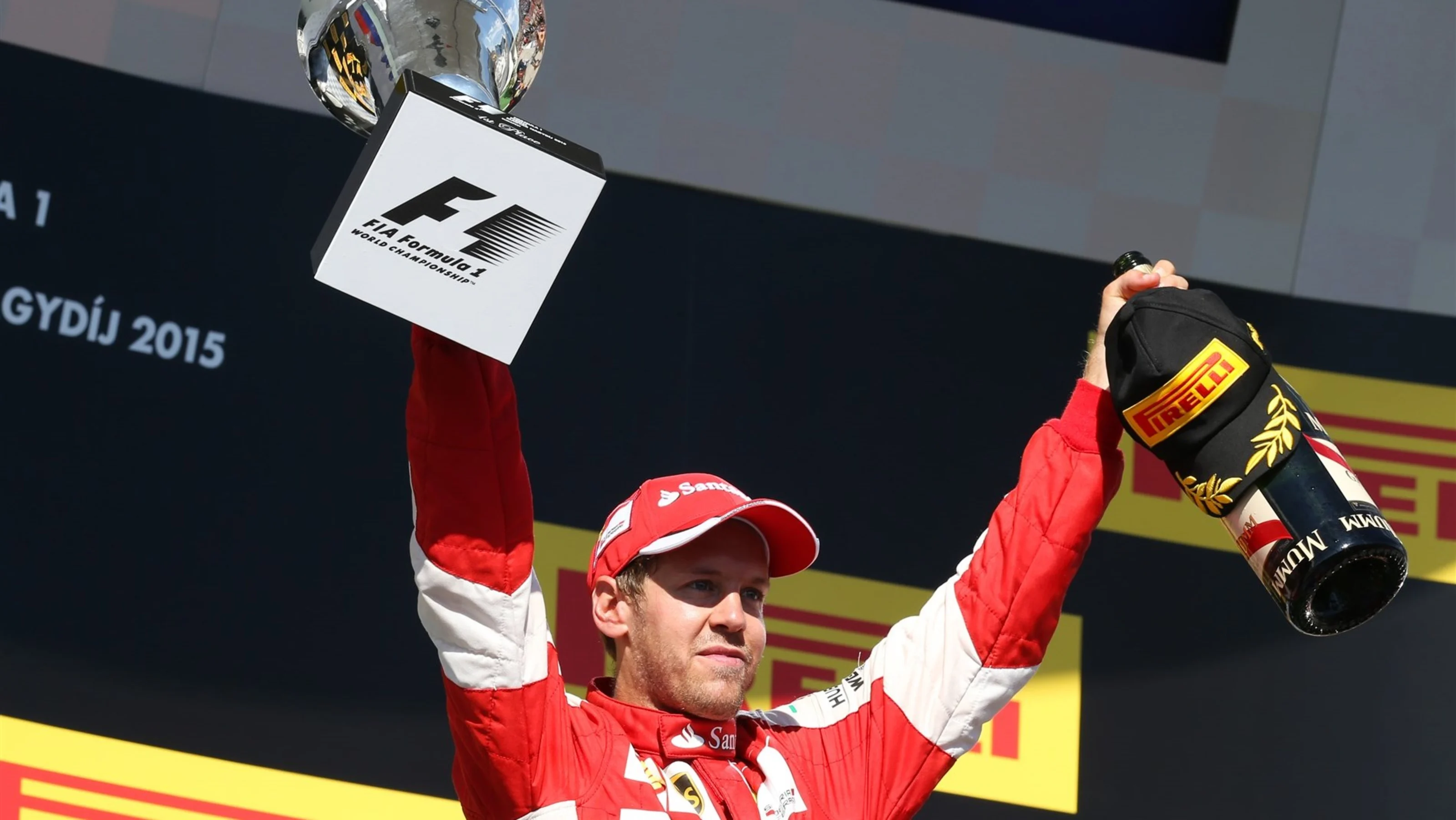 Race winner Sebastian Vettel (GER) Ferrari celebrates with the trophy and the champagne on the