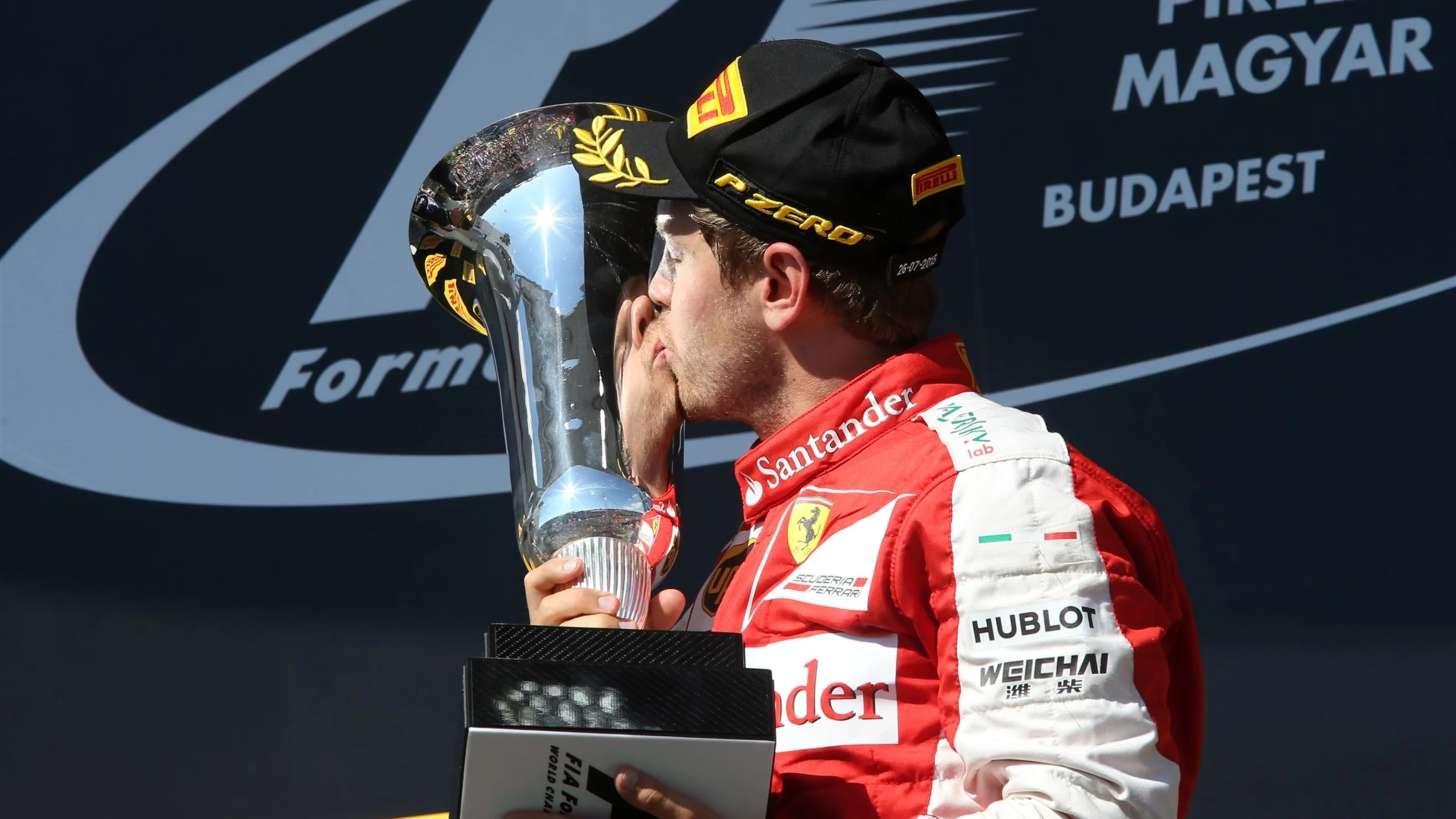 Race winner Sebastian Vettel (GER) Ferrari celebrates and kisses the trophy on the podium at