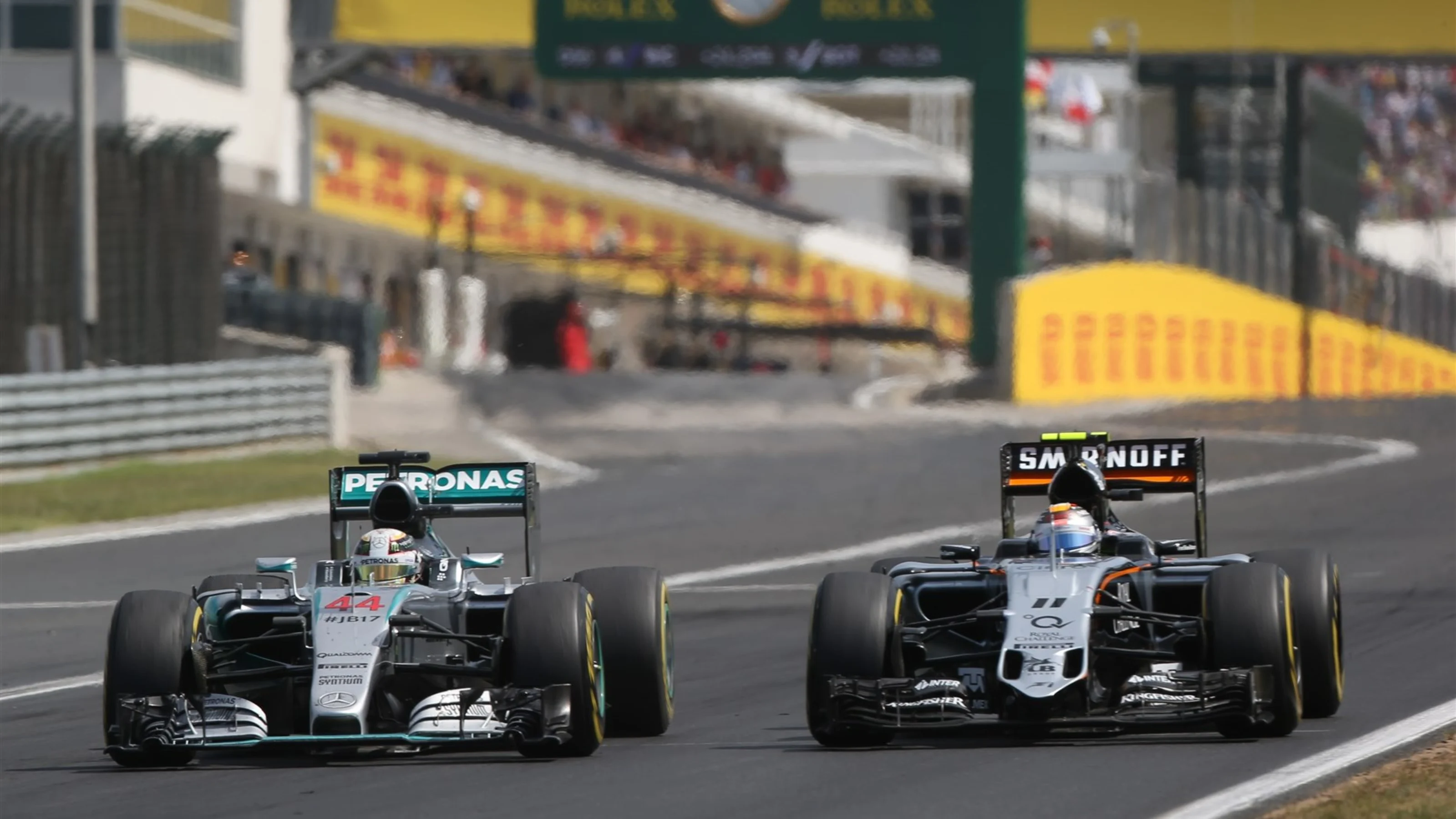 Lewis Hamilton (GBR) Mercedes AMG F1 W06 and Sergio Perez (MEX) Force India VJM08 battle at Formula