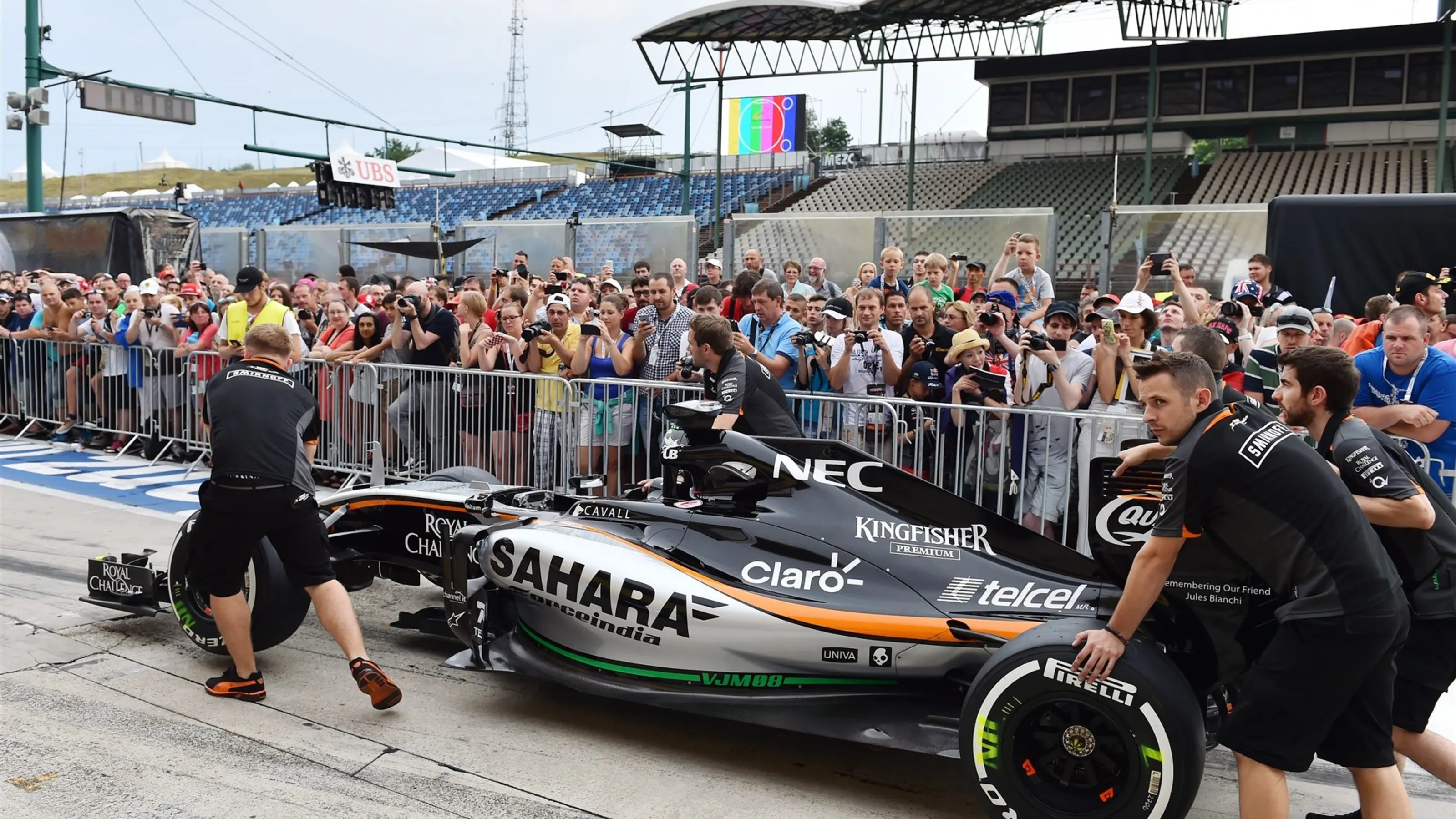 Force India mechanics push the Force India VJM08 past the fans in pit lane at Formula One World
