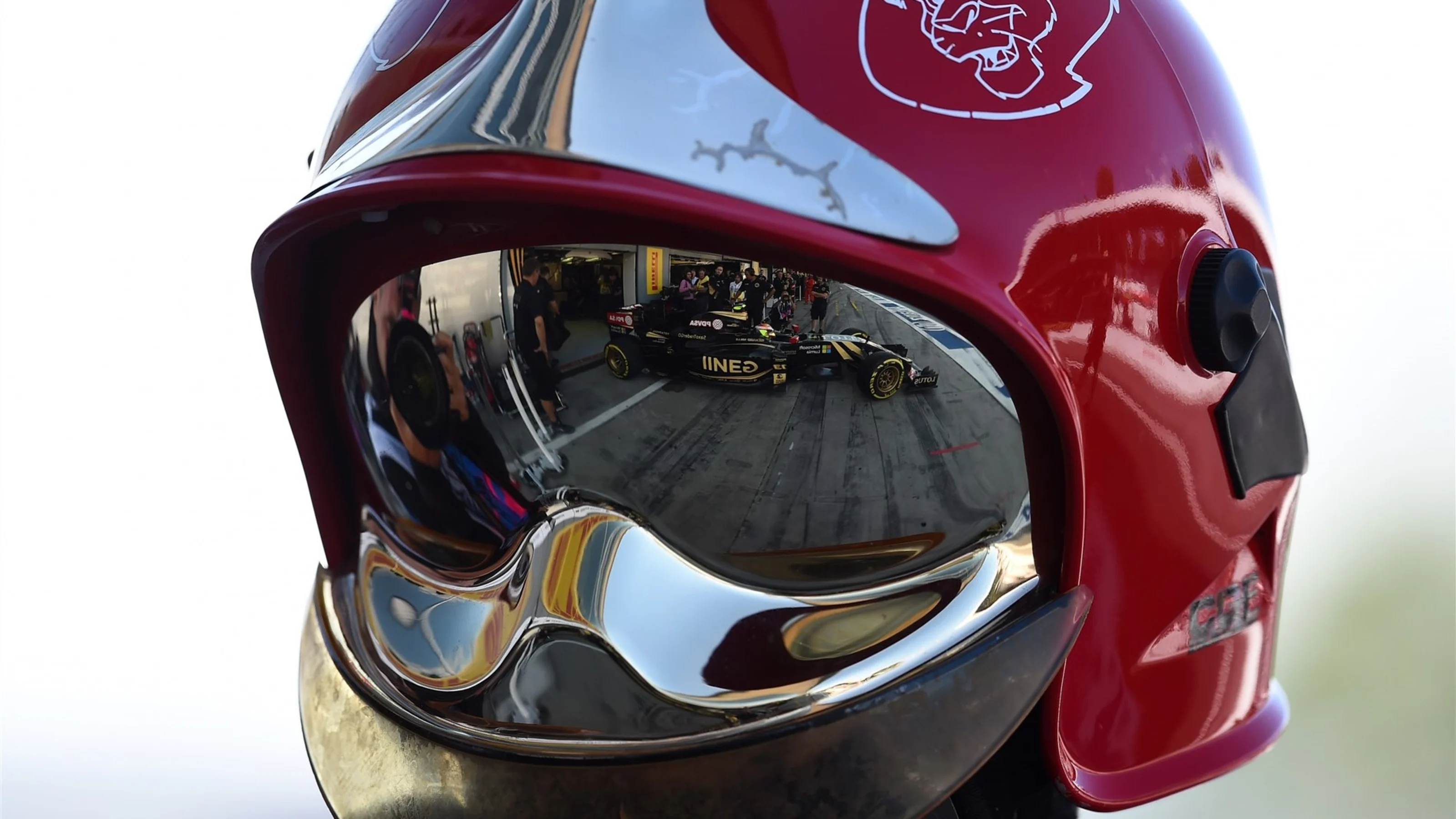 Pastor Maldonado (VEN) Lotus E23 Hybrid reflected in a firemans helmet at Formula One World