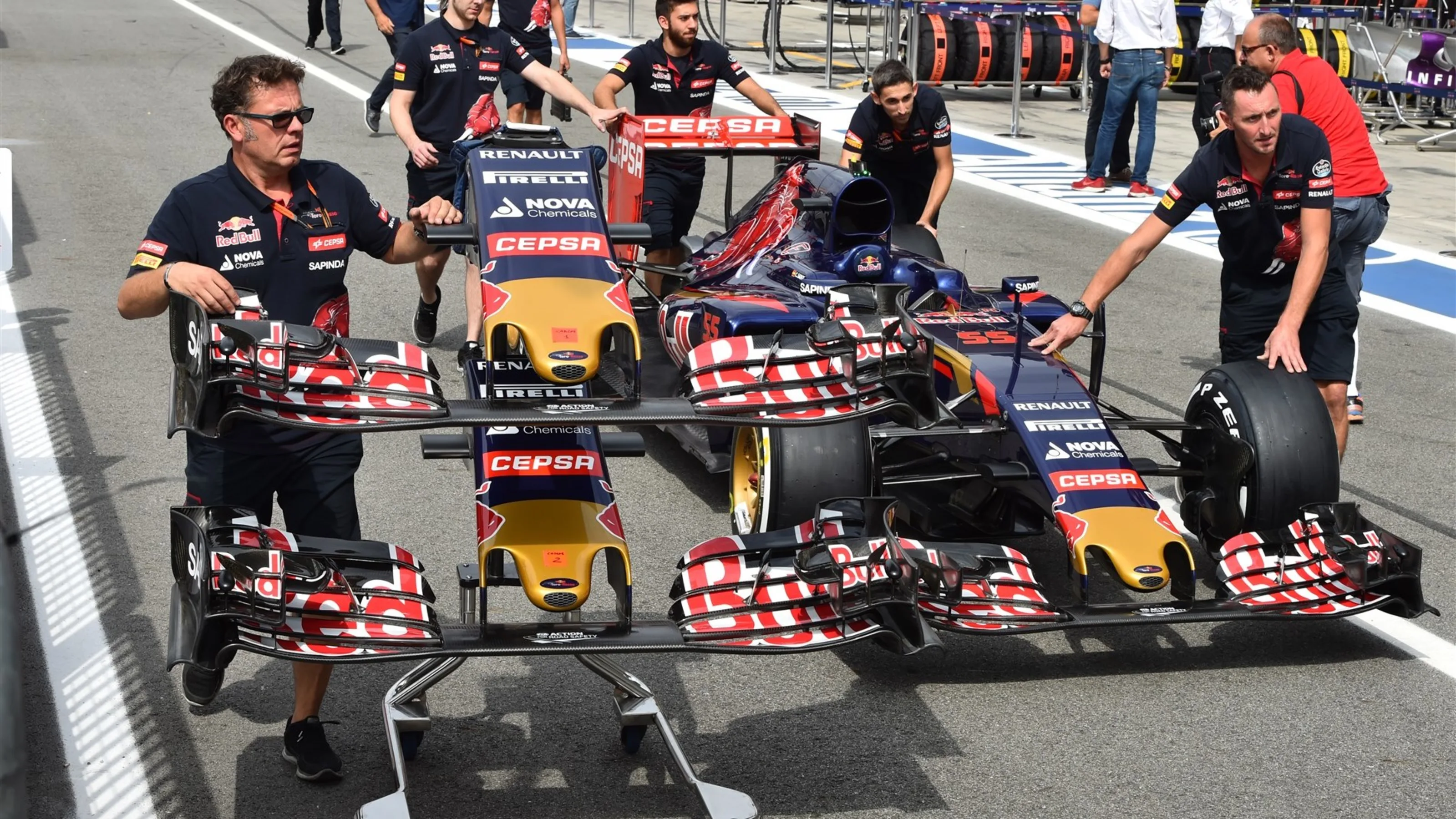 Scuderia Toro Rosso mechanics with Scuderia Toro Rosso STR10 nose and front wings and Scuderia Toro