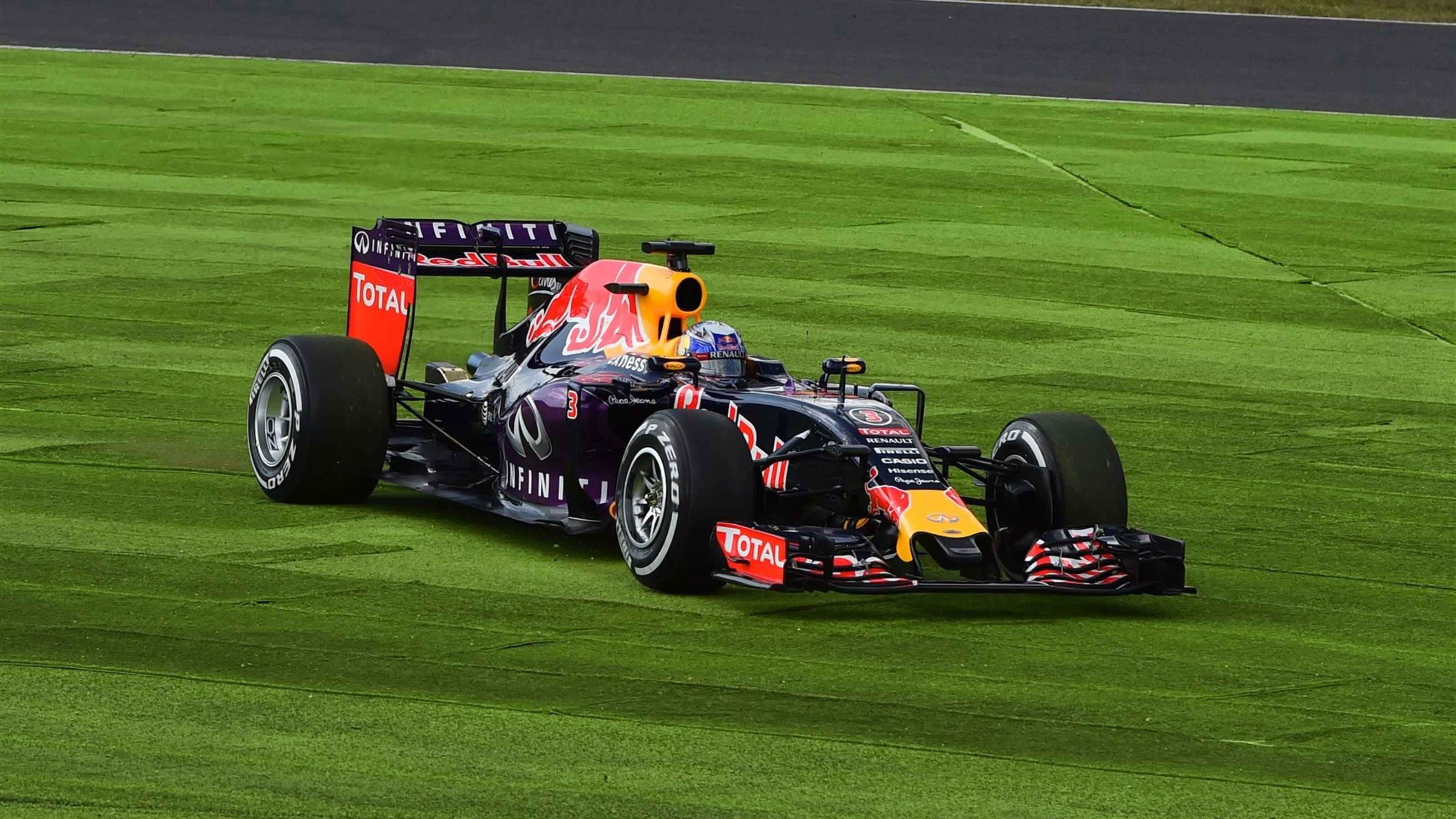 Daniel Ricciardo (AUS) Red Bull Racing RB11 takes a trip across the grass on lap one with a rear