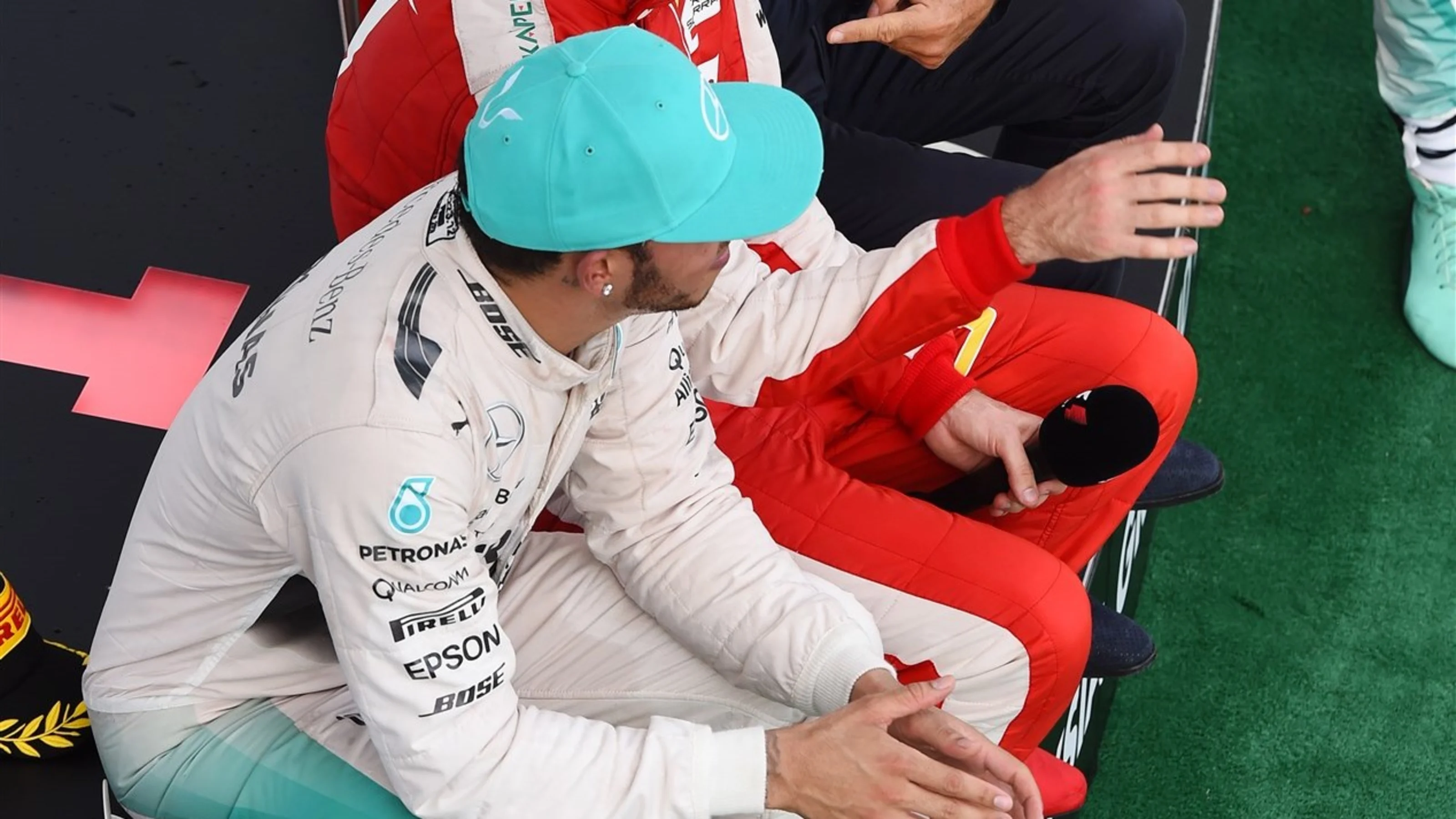 Lewis Hamilton (GBR) Mercedes AMG F1 and Sebastian Vettel (GER) Ferrari sit down on the podium with