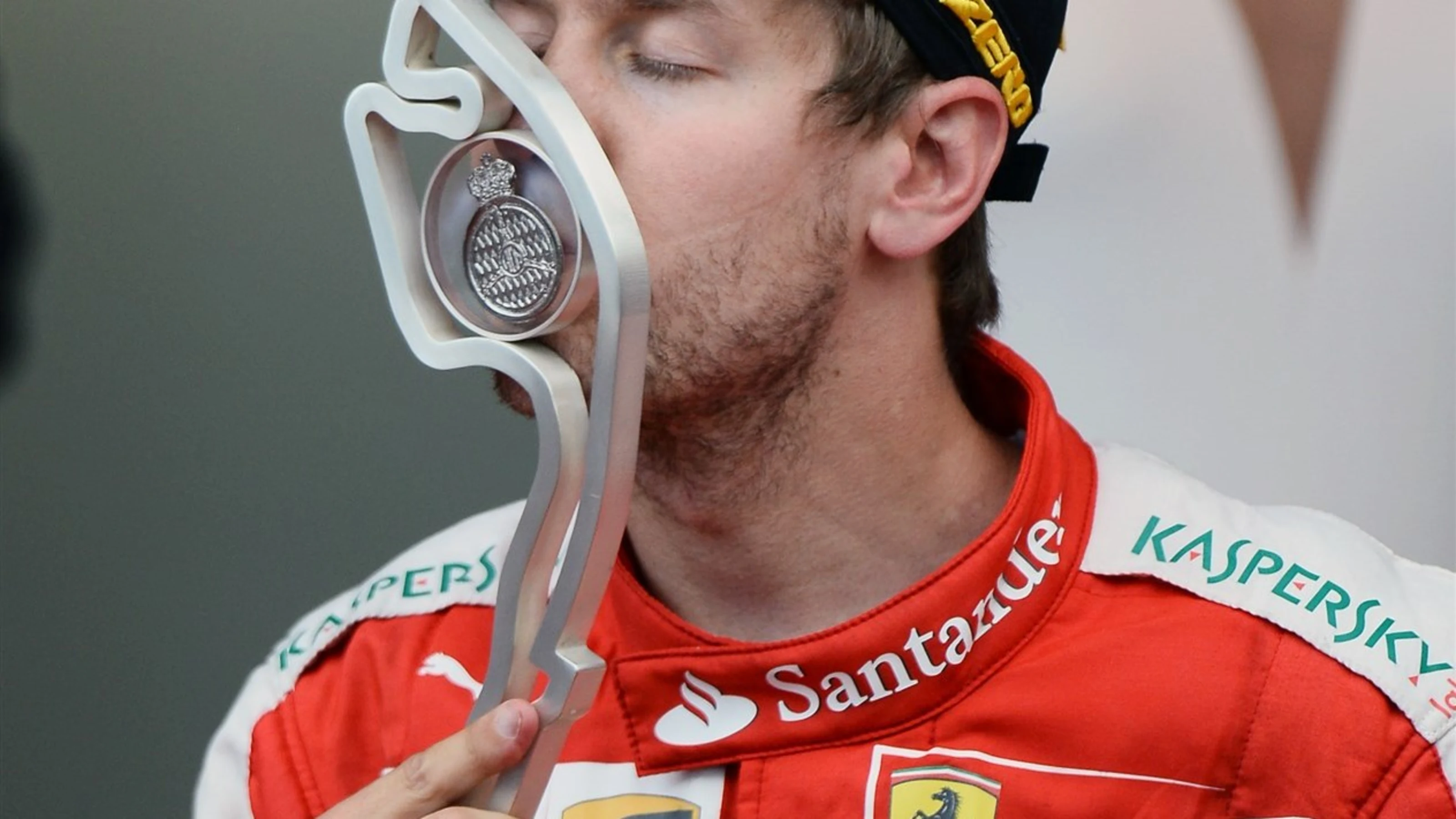 Sebastian Vettel (GER) Ferrari celebrates by kissing the trophy on the podium at Formula One World