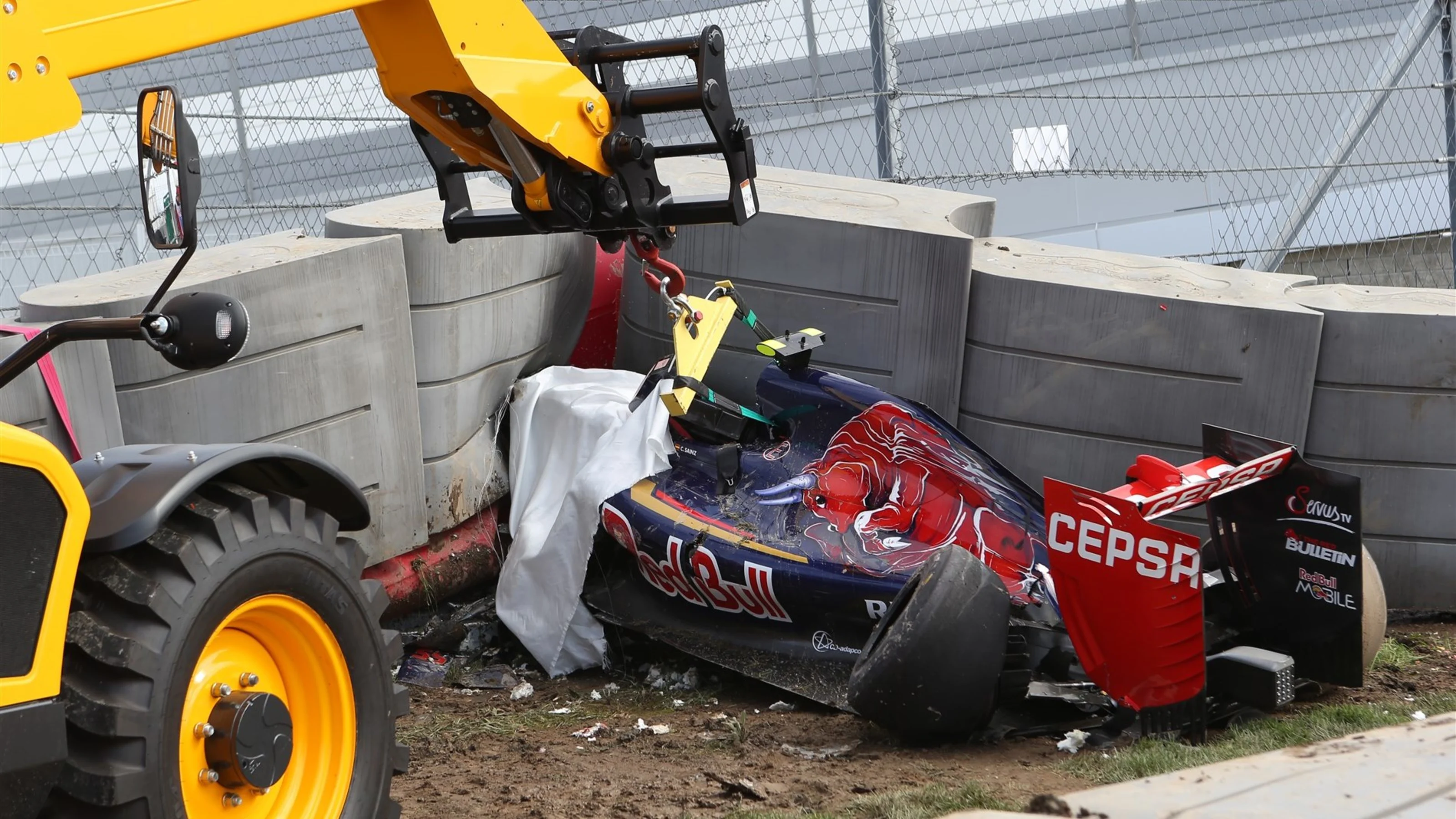 The crashed car of Sainz jr (ESP) Scuderia Toro Rosso is recovered from under the tech pro barrier