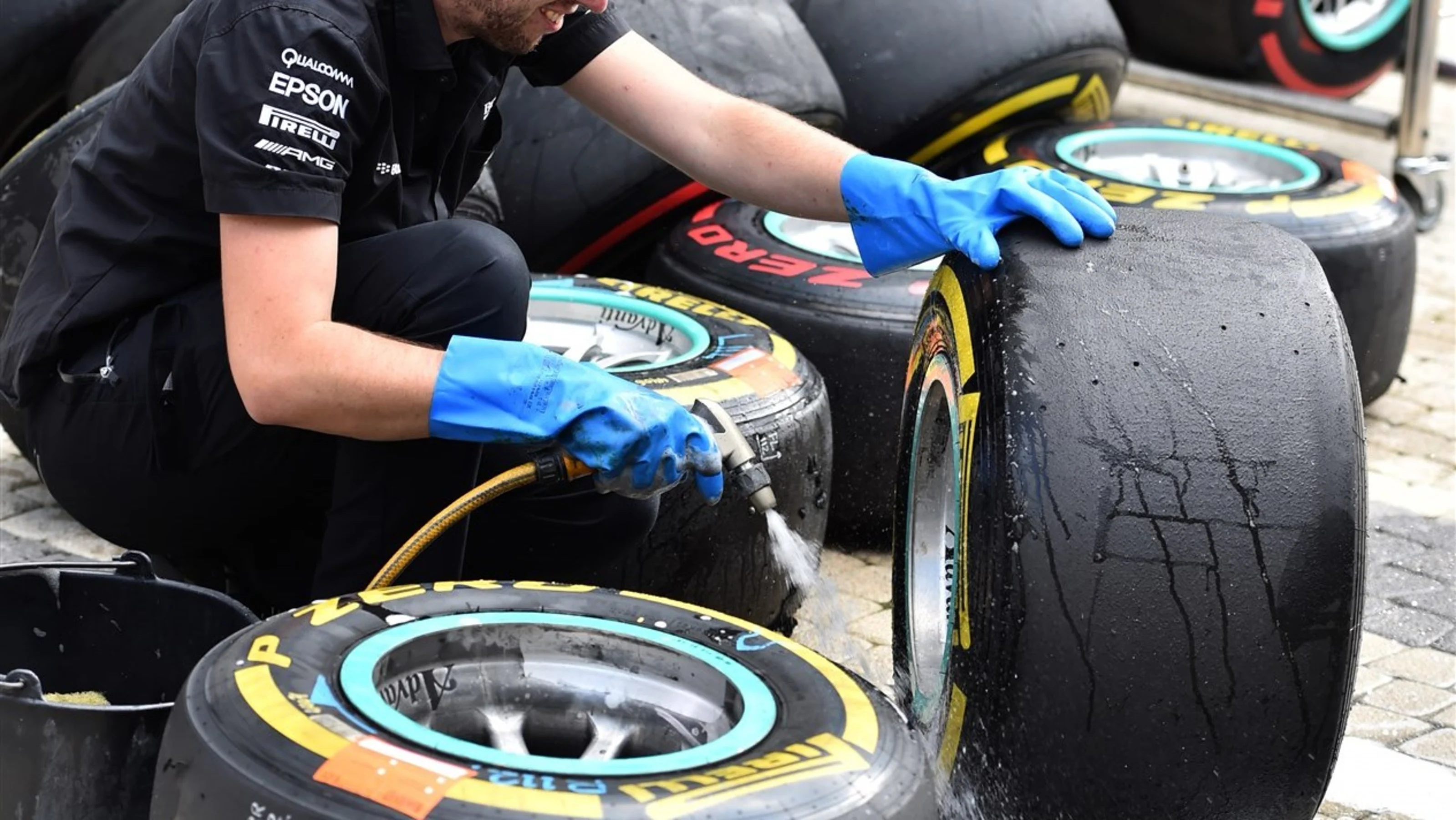 Mercedes AMG F1 mechanic washes pit tyres and wheels at Formula One World Championship, Rd15,