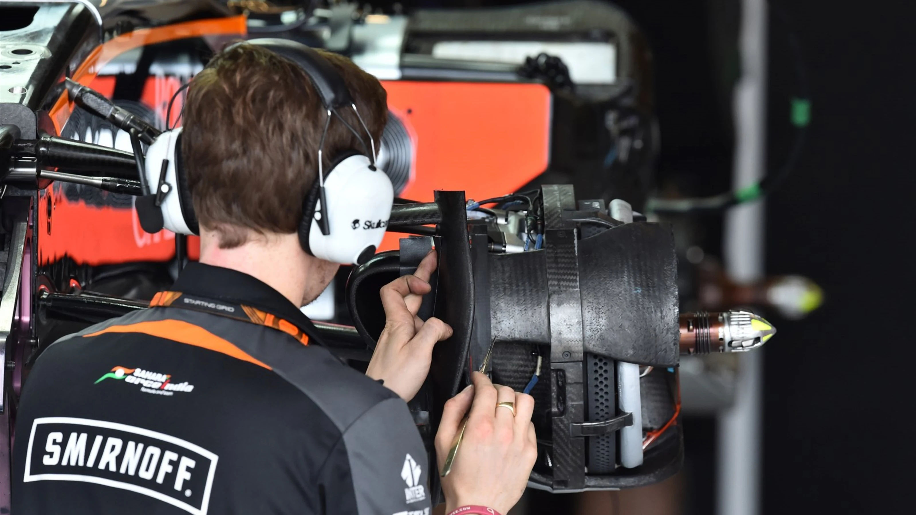 Force India F1 mechanic works on Force India VJM08 front wheel hub at Formula One World