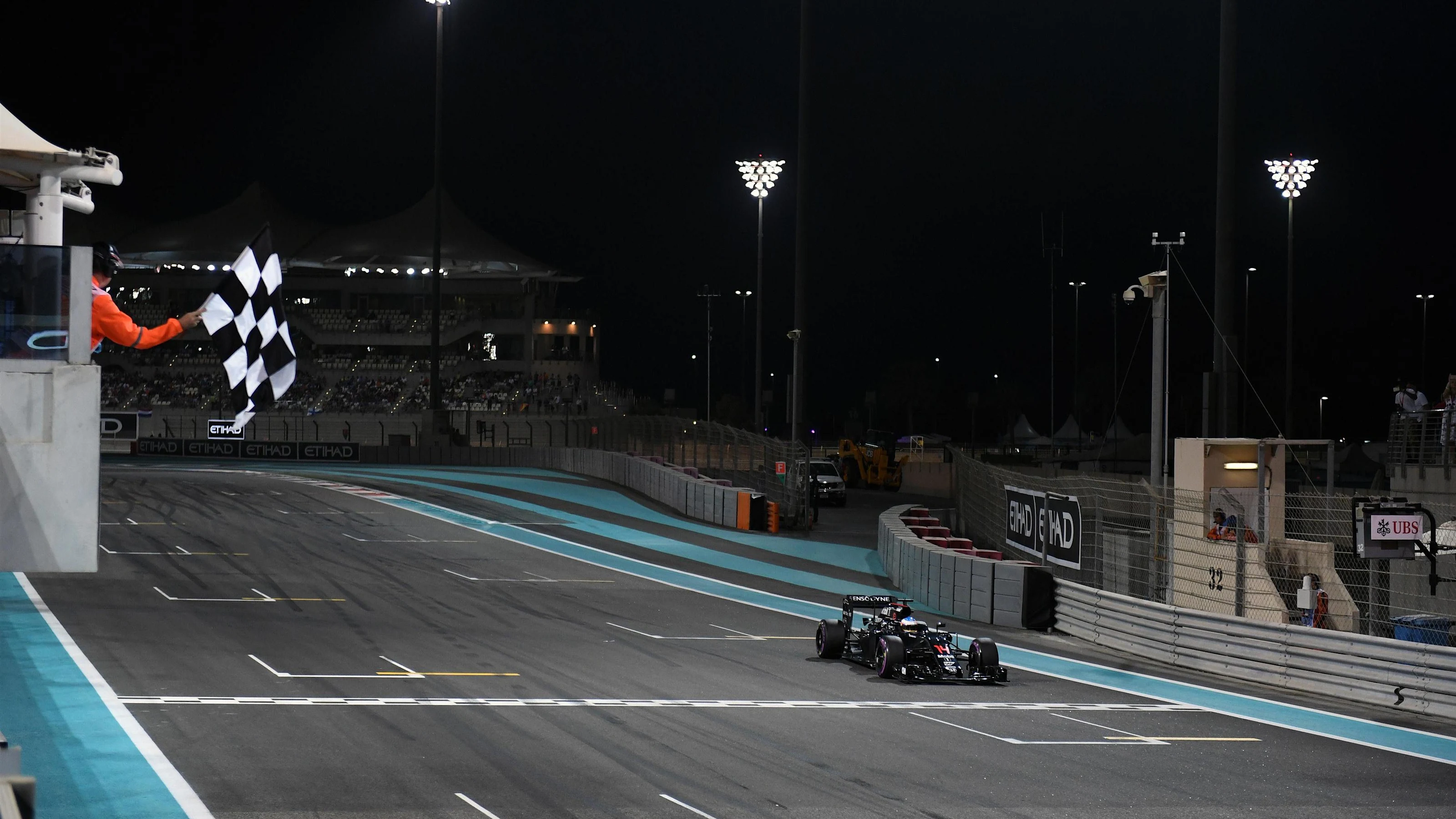 Fernando Alonso (ESP) McLaren MP4-31 takes the chequered flag at the end of Qualifying at Formula