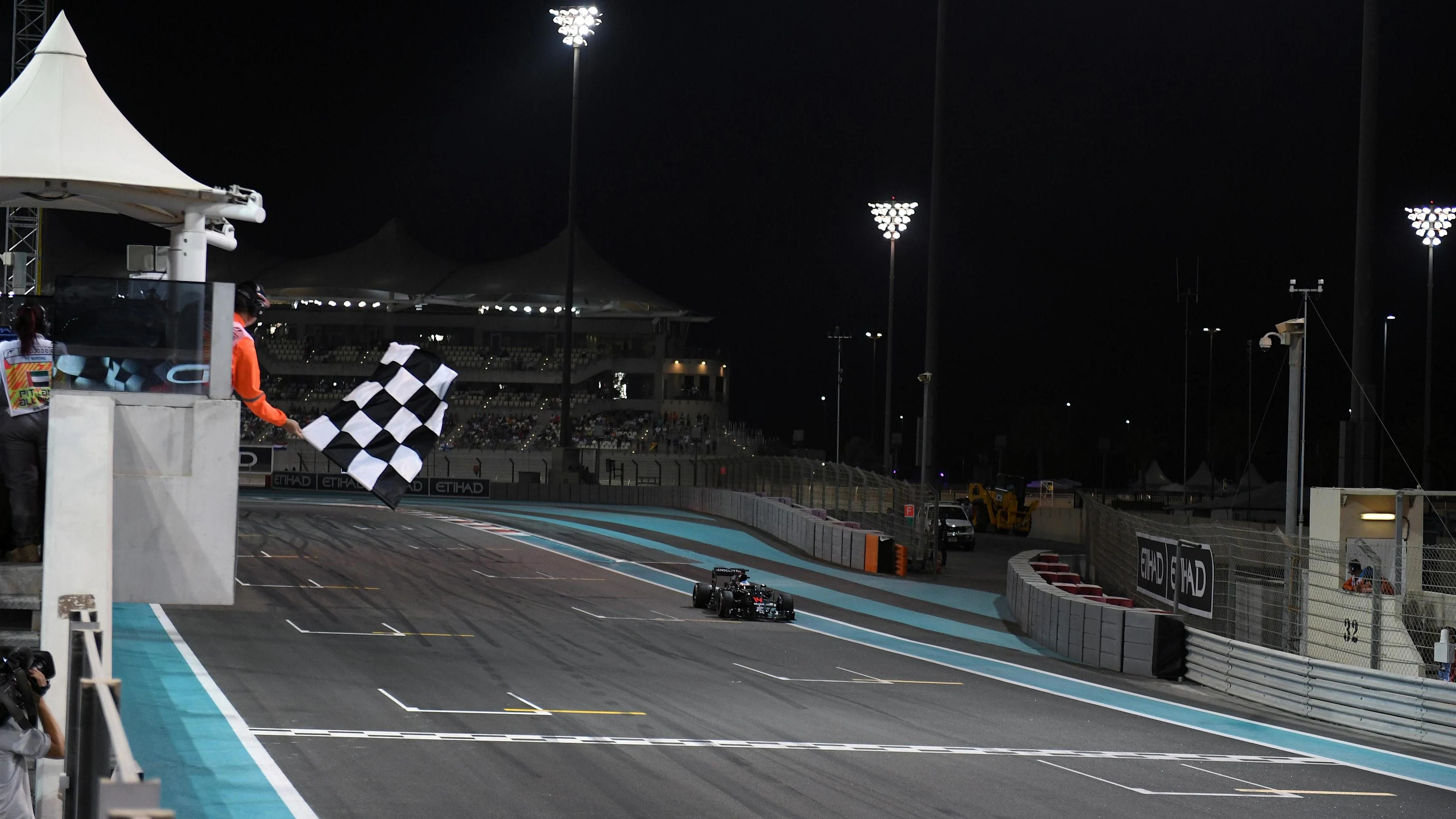 Fernando Alonso (ESP) McLaren MP4-31 takes the chequered flag at the end of Qualifying at Formula