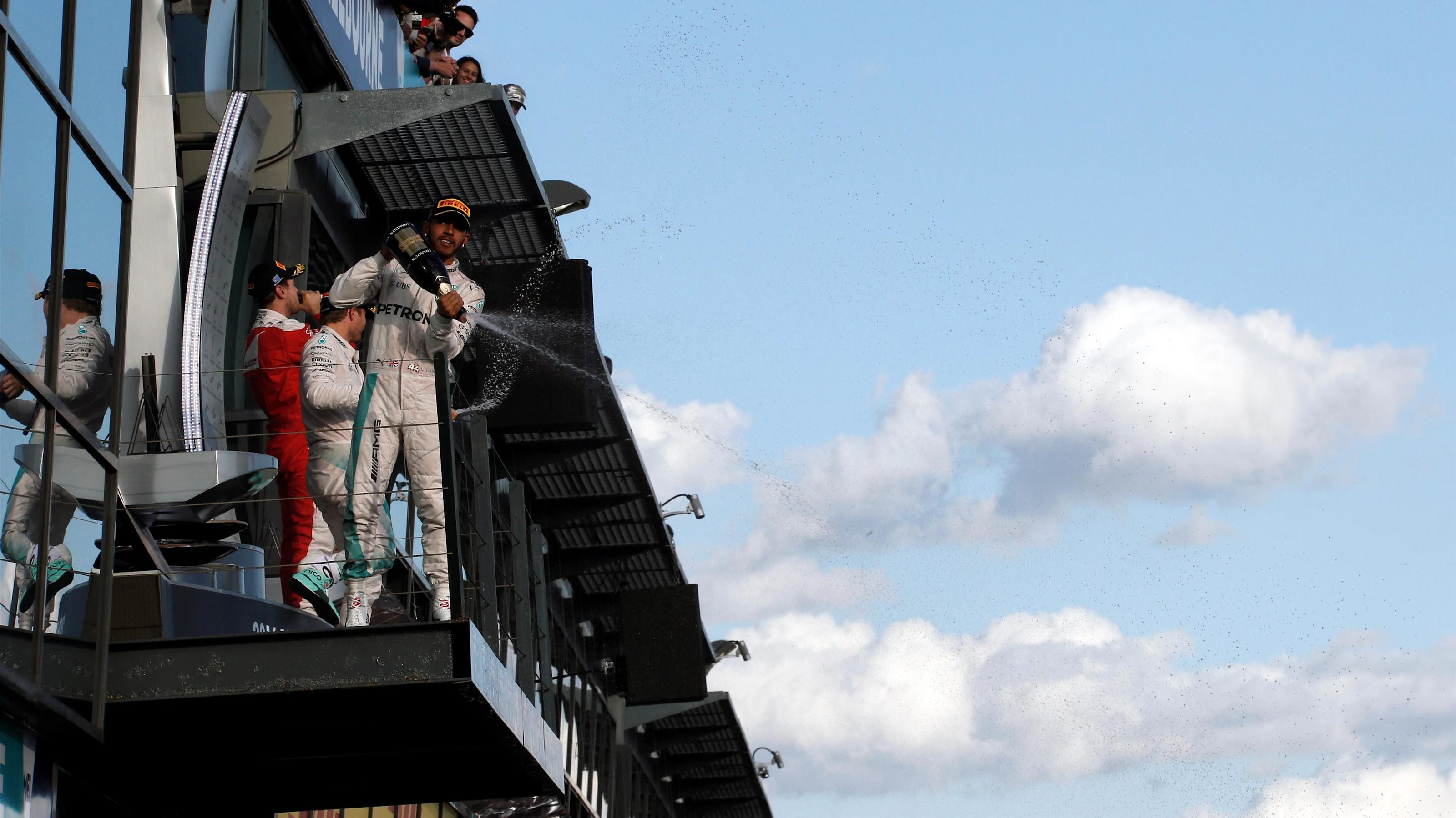 Lewis Hamilton (GBR) Mercedes AMG F1 celebrates with champagne on the podium with race winner Nico