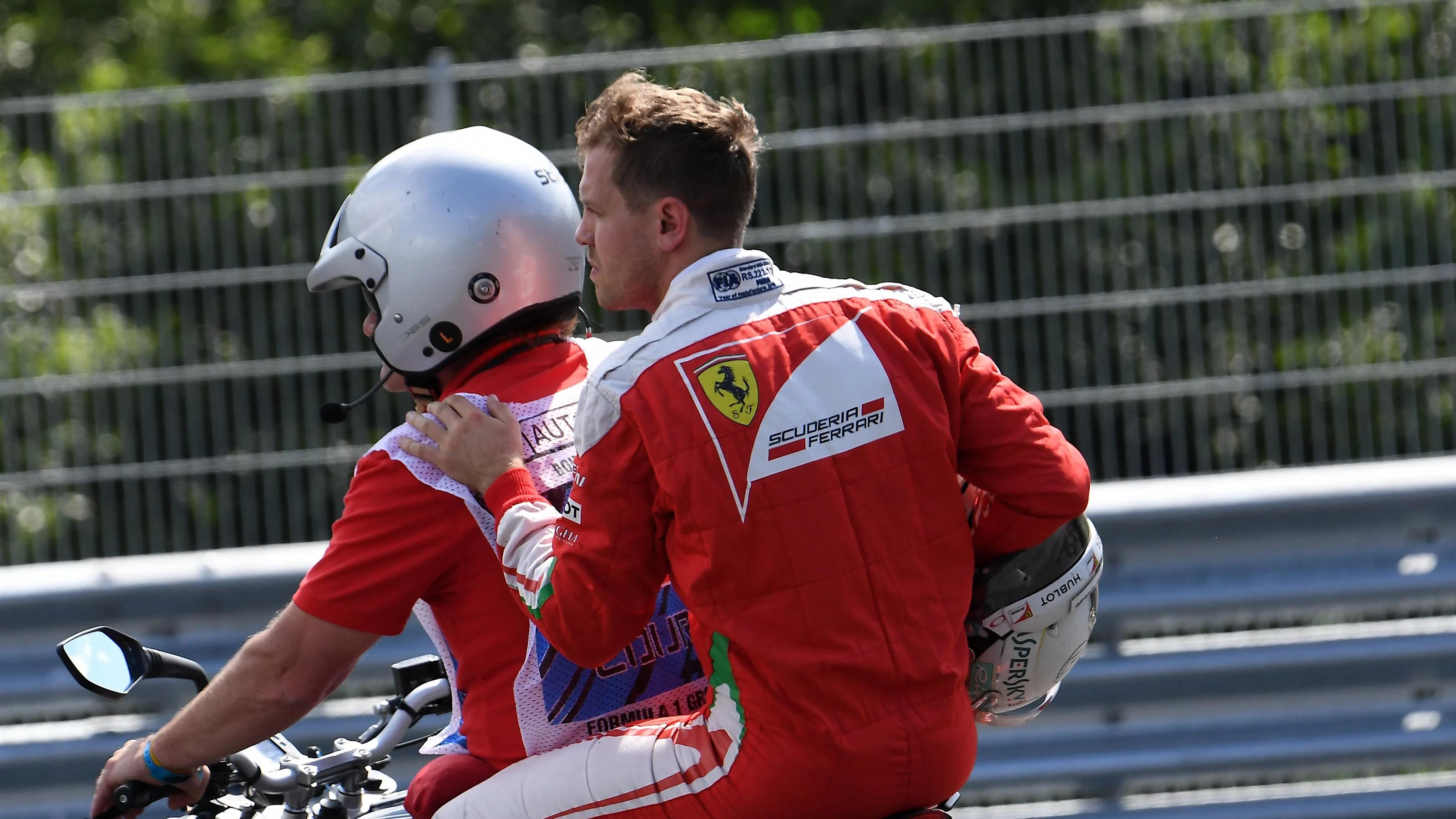 Sebastian Vettel (GER) Ferrari span out in FP2 and hitches a lift on a scooter at Formula One World