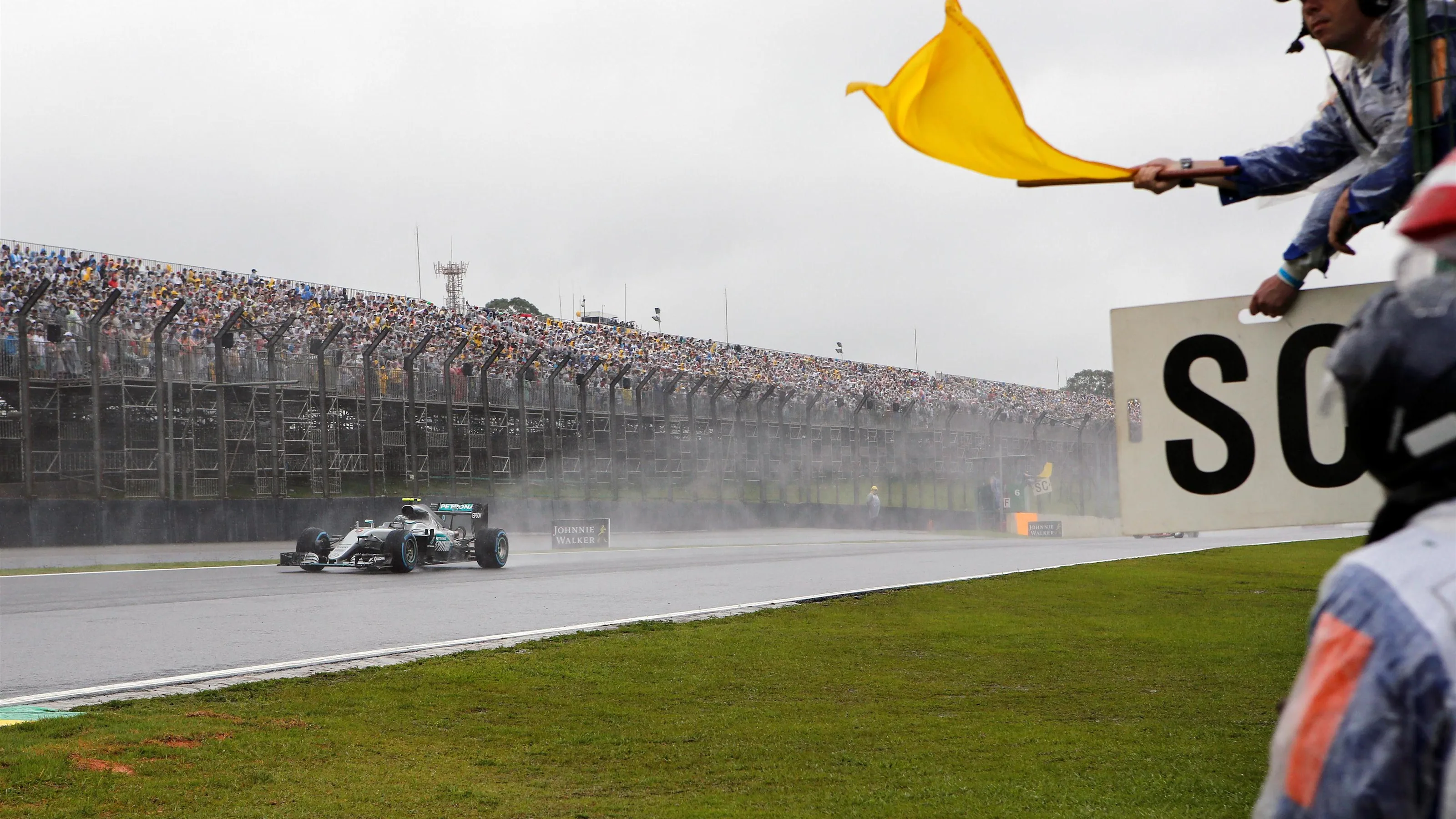 Nico Rosberg (GER) Mercedes-Benz F1 W07 Hybrid and marshal with yellow flag at Formula One World