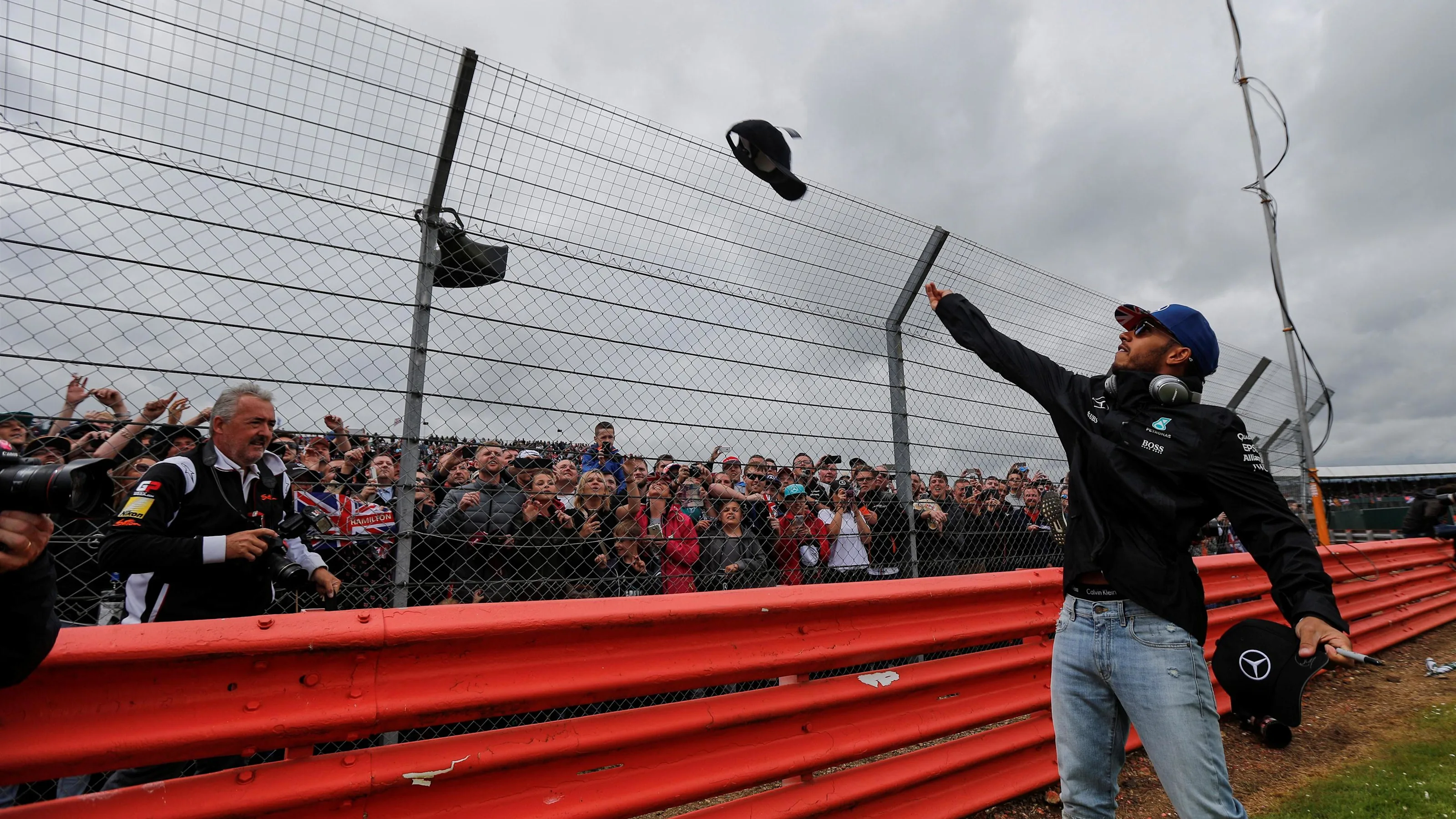 Lewis Hamilton (GBR) Mercedes AMG F1 throws caps to the fans on the drivers parade at Formula One