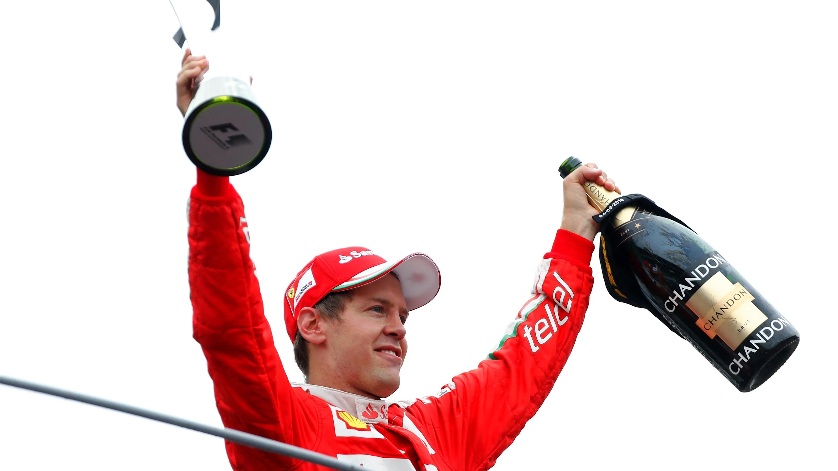 Sebastian Vettel (GER) Ferrari celebrates on the podium with the trophy and the champagne at