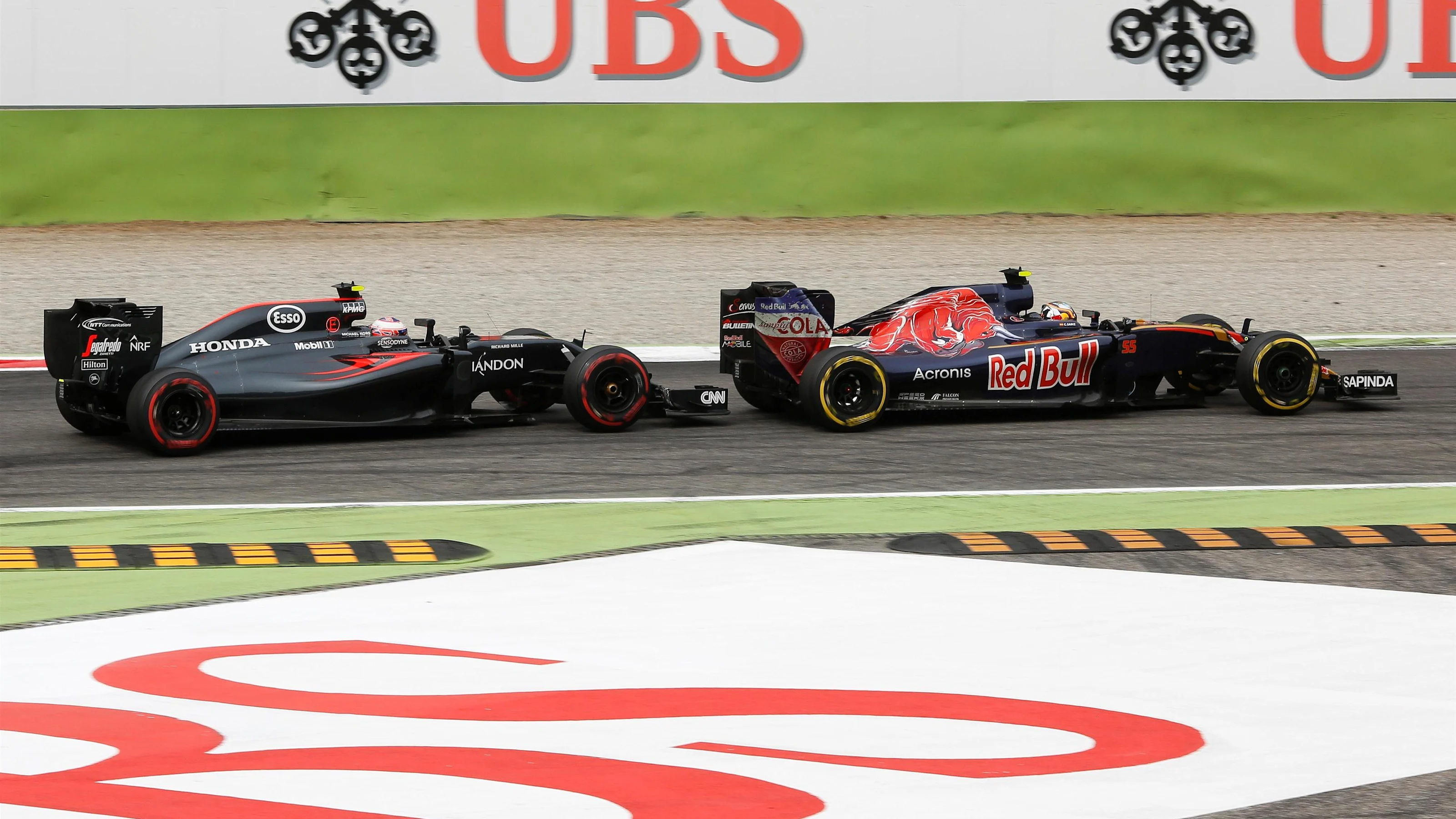 Jenson Button (GBR) McLaren MP4-31 and Carlos Sainz jr (ESP) Scuderia Toro Rosso STR11 battle at